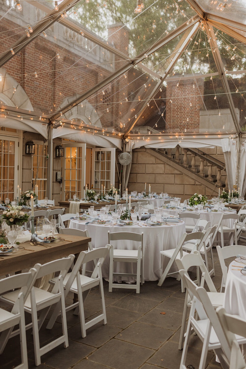 blue and gold table settings at tent garden wedding