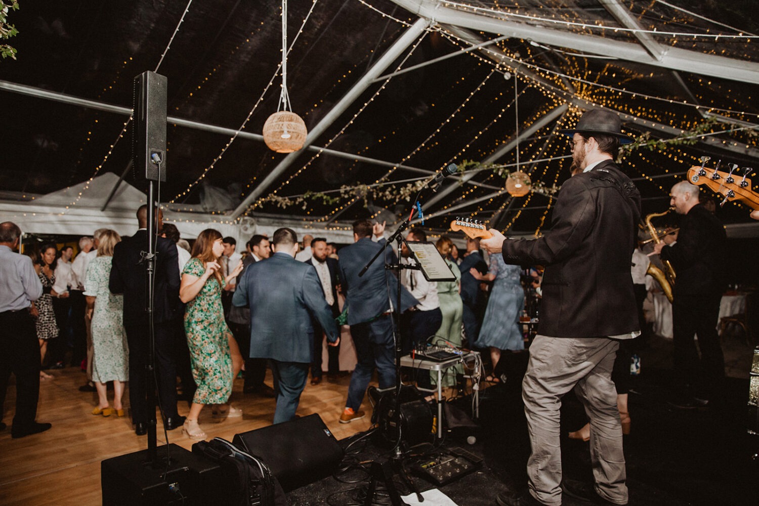 wedding guests dance at outdoor wedding with tent reception