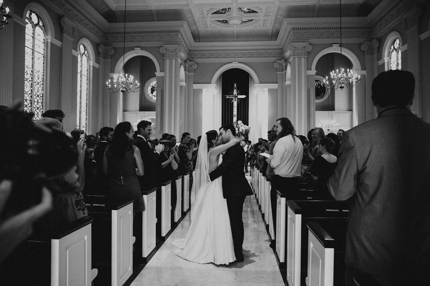 couple kisses at Catholic wedding ceremony