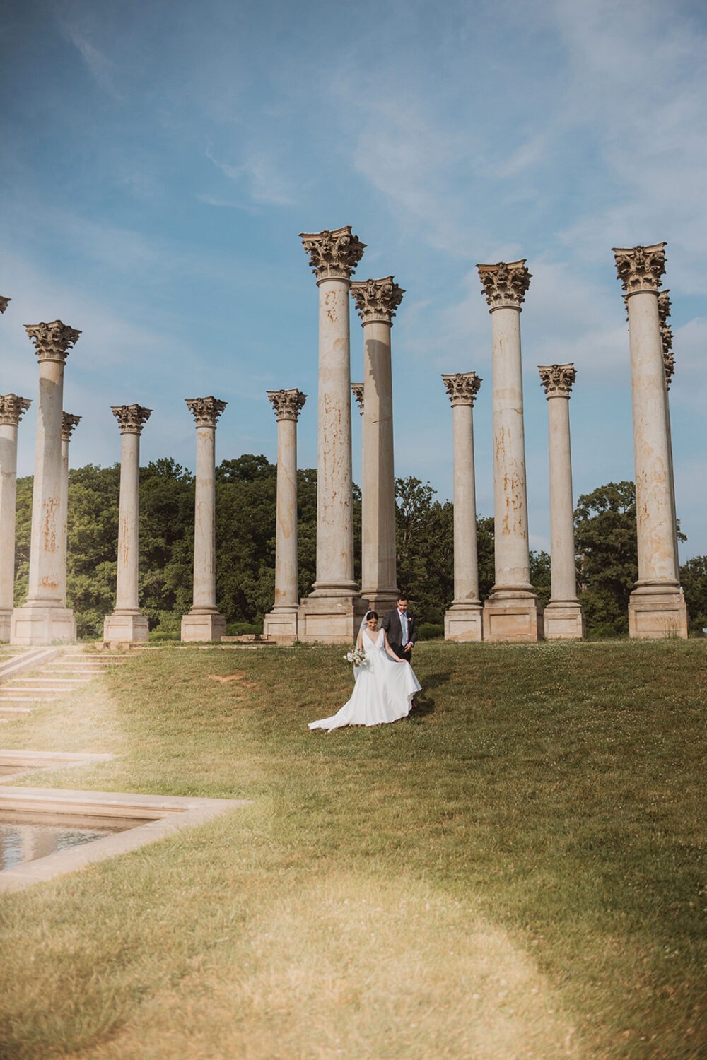 couple walks beside Capitol Columns at National Arboretum DC wedding