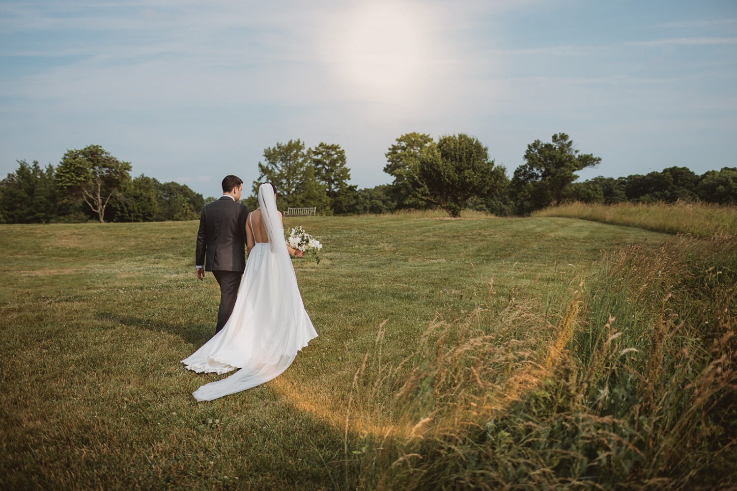 couple walks in field at sunset outdoor DC wedding