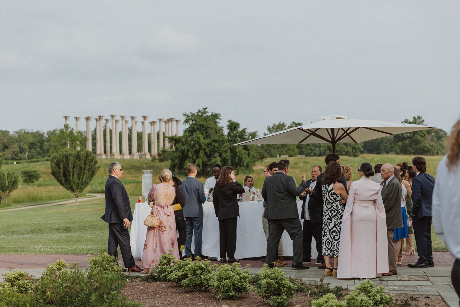 wedding guests mingle during cocktail hour in front of Capitol Columns at National Arboretum 