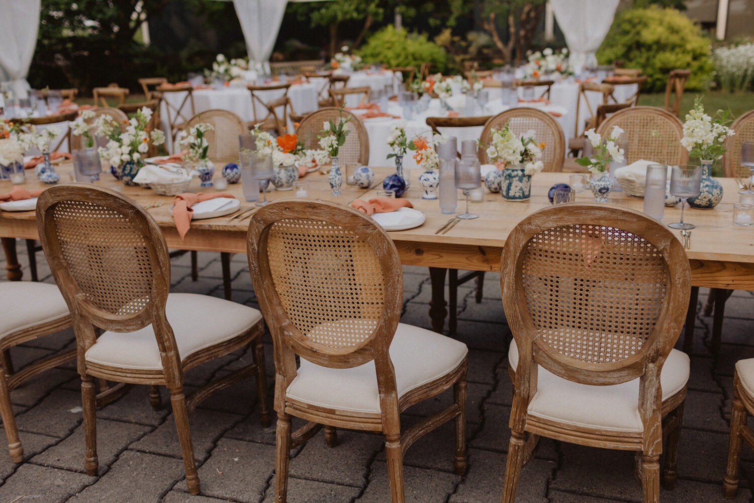 wedding decor table setting with white florals and wicker chairs