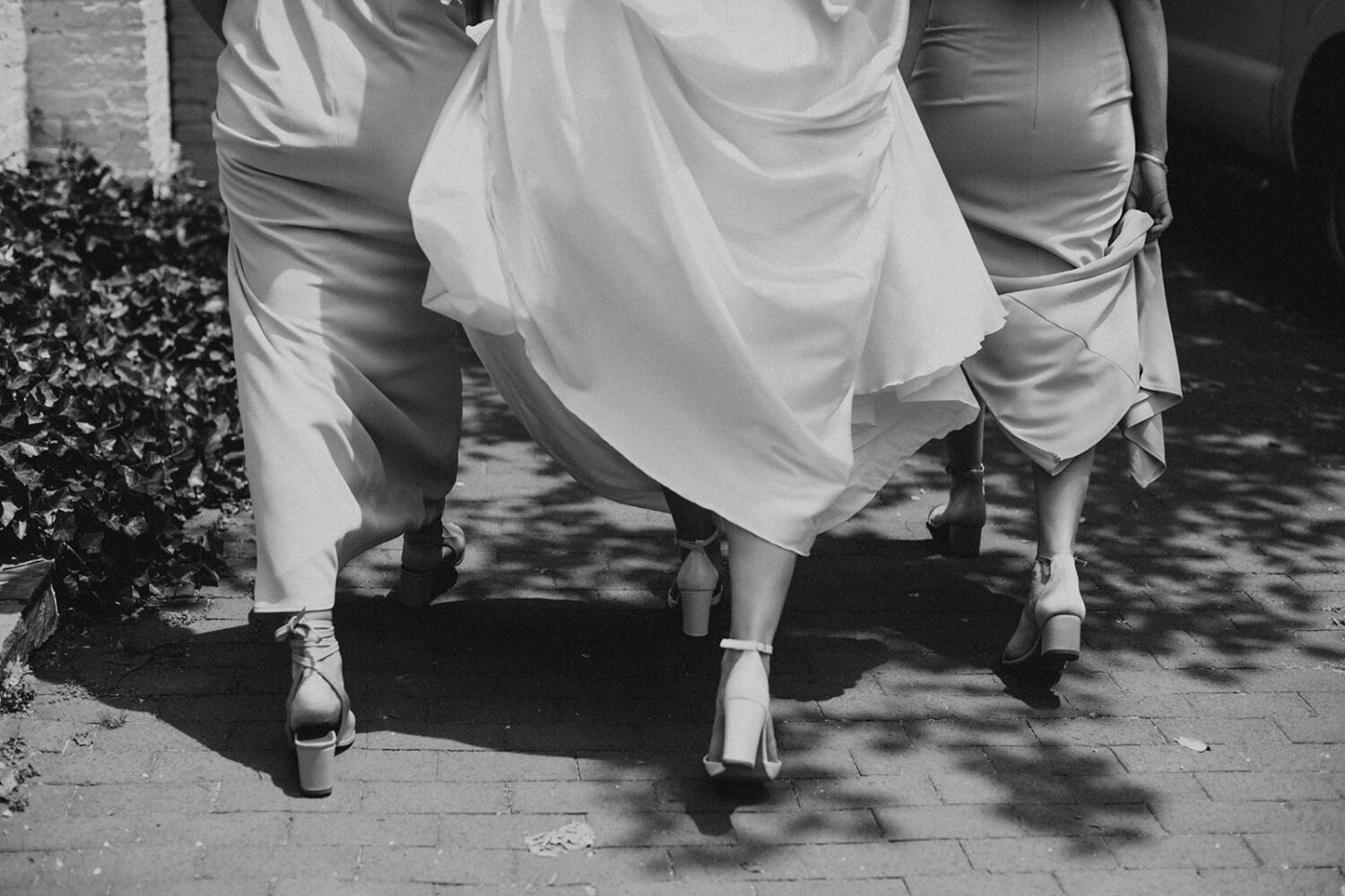 couple walks along street with bridesmaids 