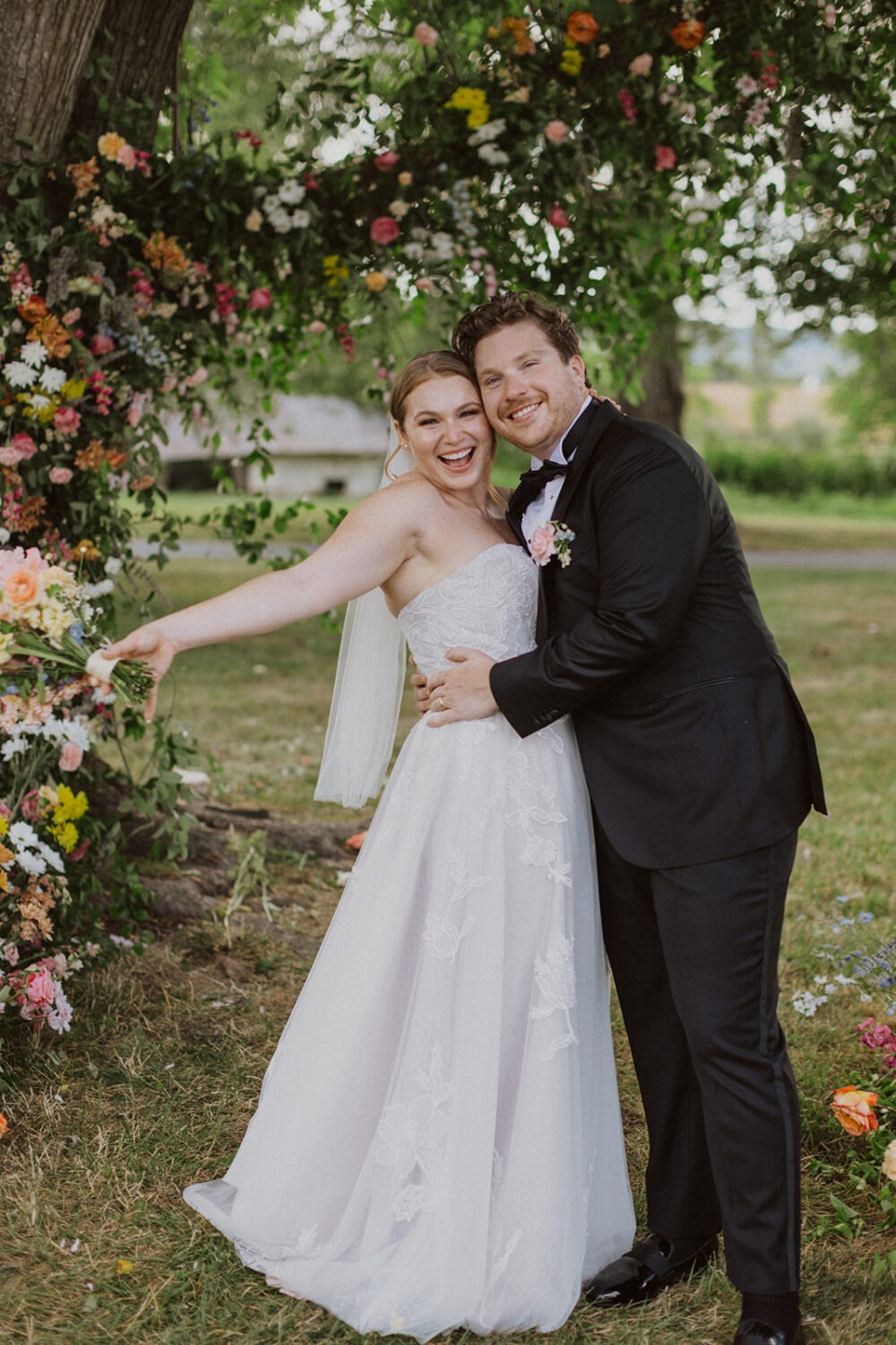 couple embraces surrounded by wedding florals