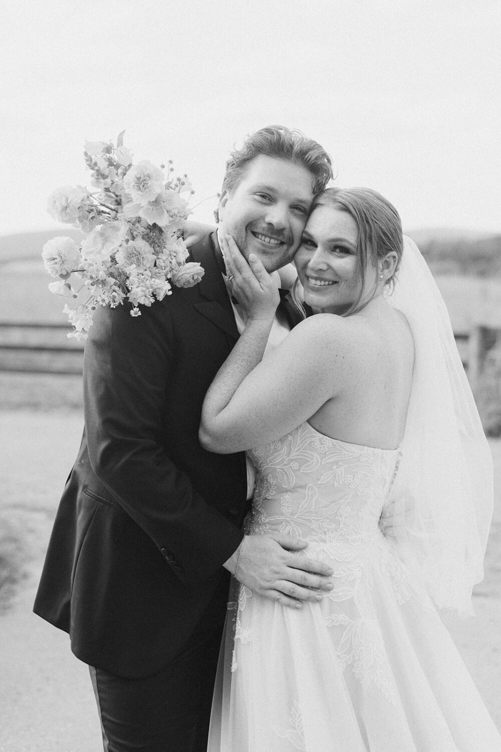 couple embraces in field at outdoor Virginia wedding