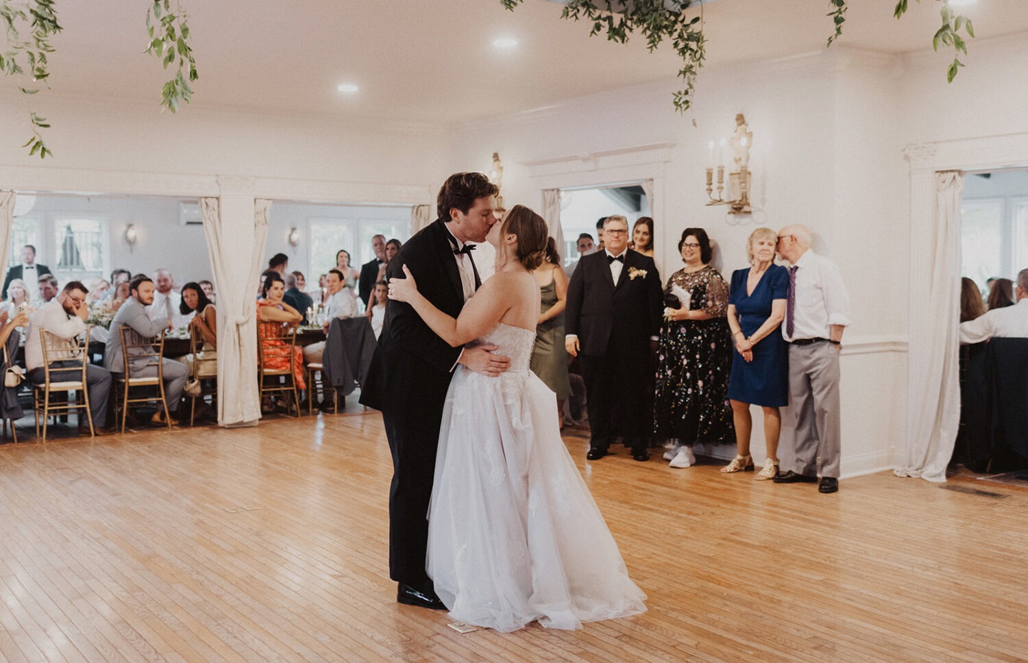 couple kisses on dance floor during wedding reception 