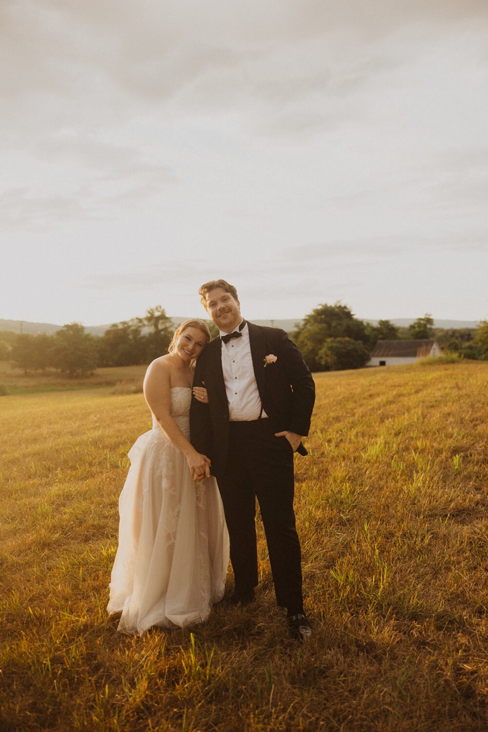 couple holds hands in field at The Manor at Airmont wedding