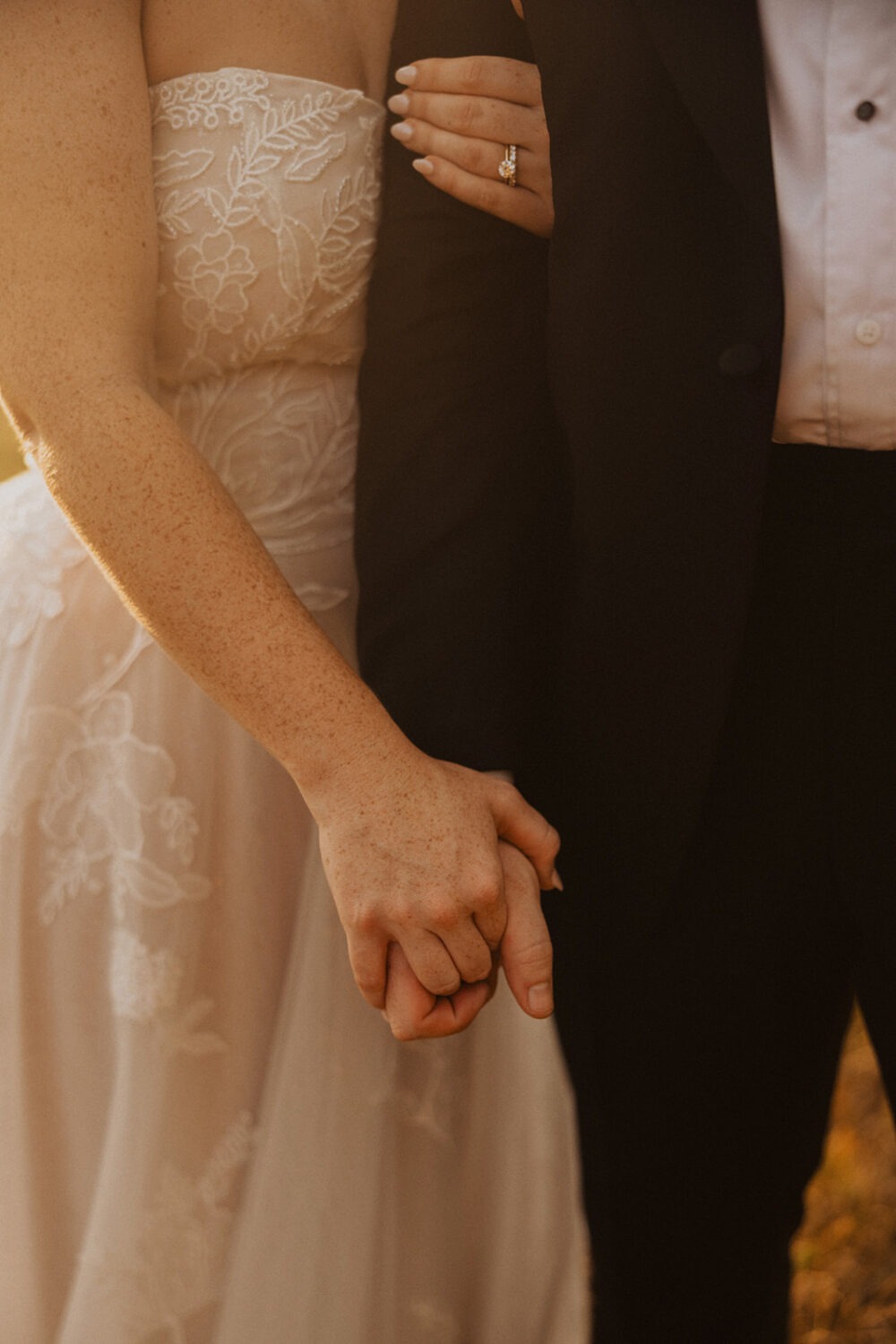 couple holds hands during sunset wedding photos