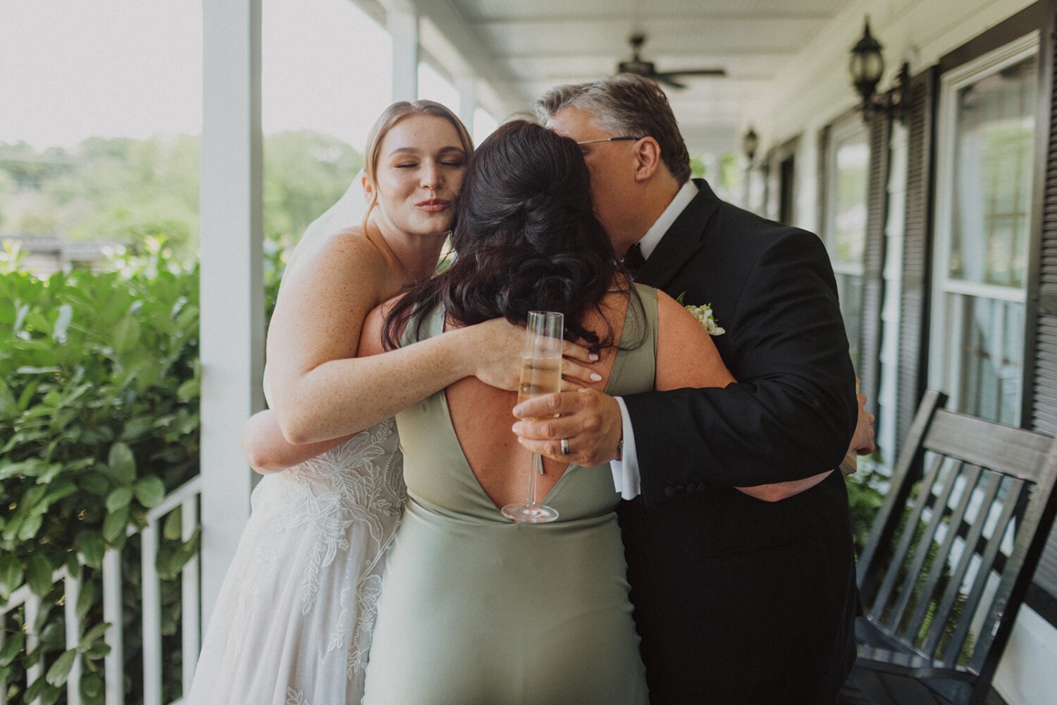 bride hugs parents during wedding first look