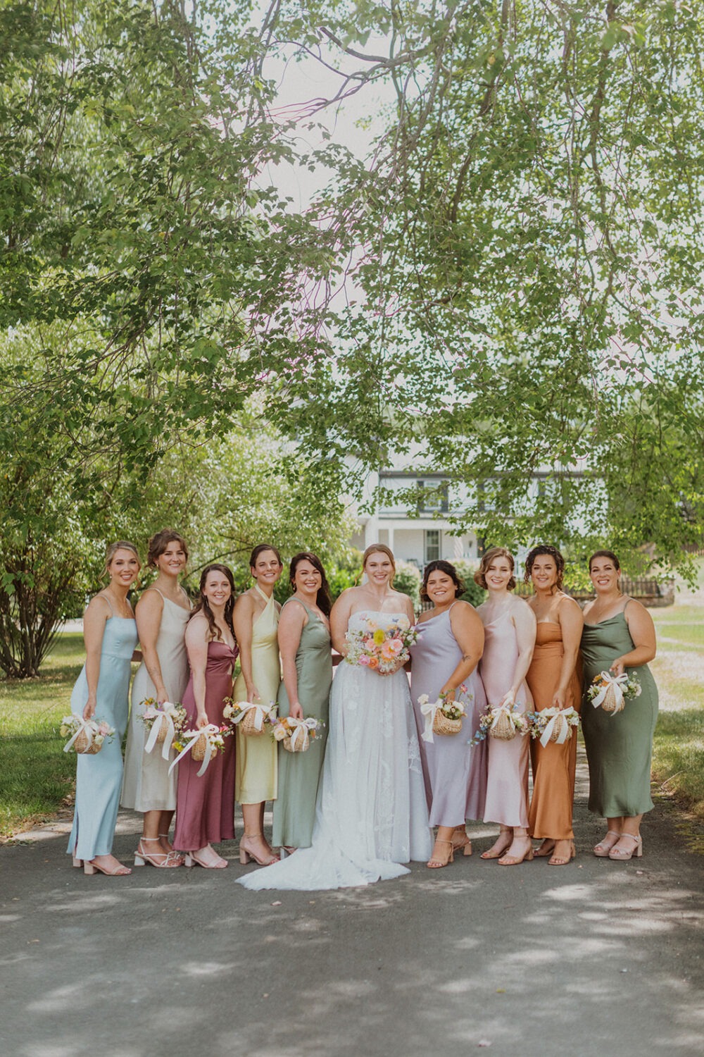 bride poses with bridesmaids holding wildflower bouquet baskets