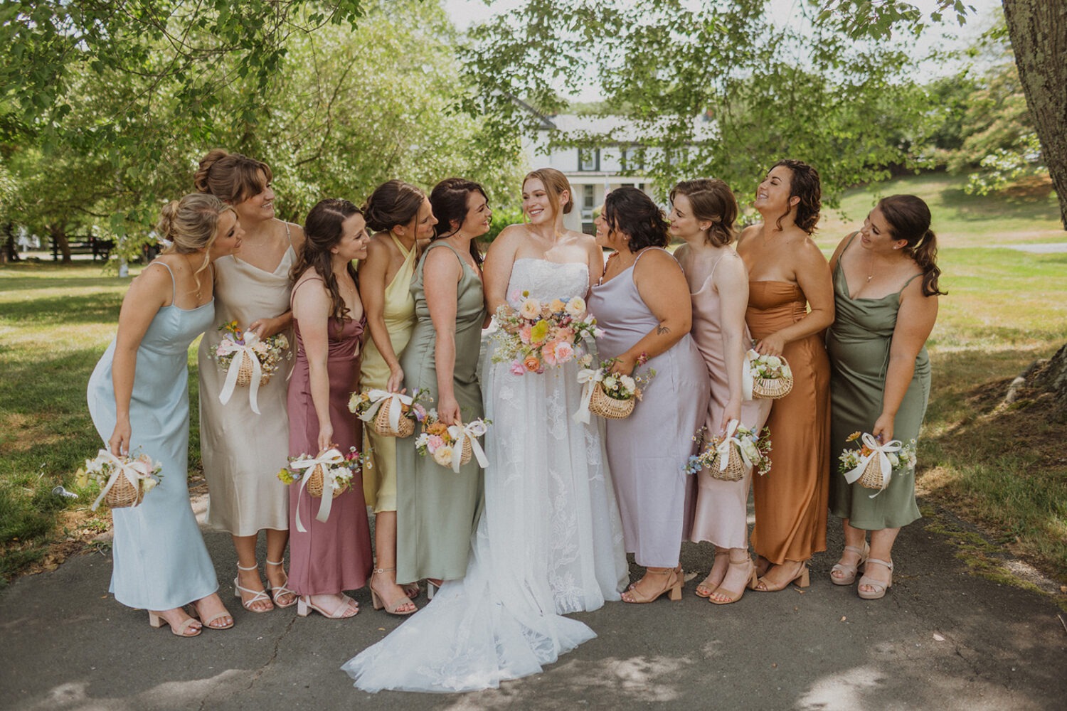 bride poses with bridesmaids holding wildflower bouquet baskets