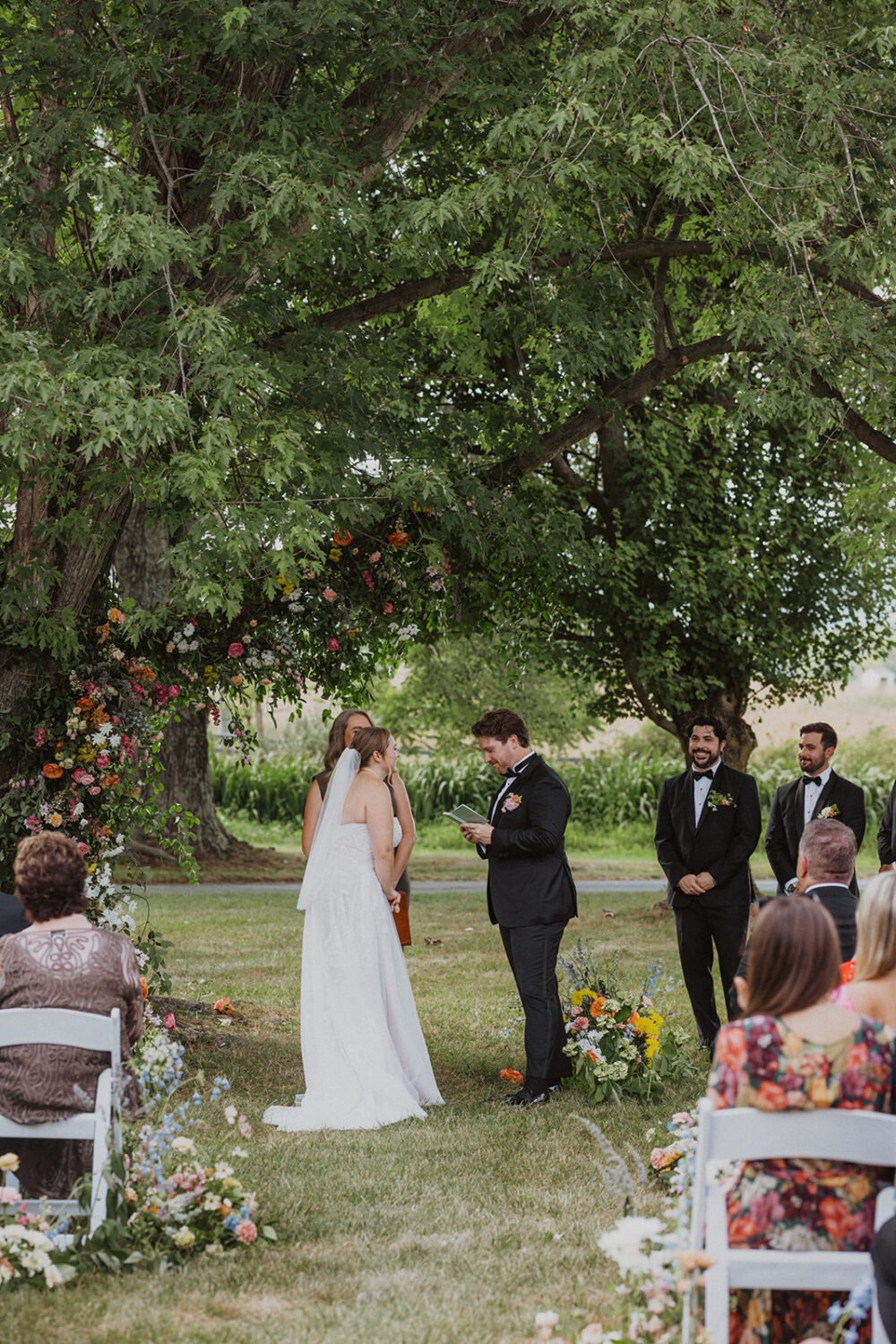 couple exchanges vows under tree  at The Manor at Airmont wedding