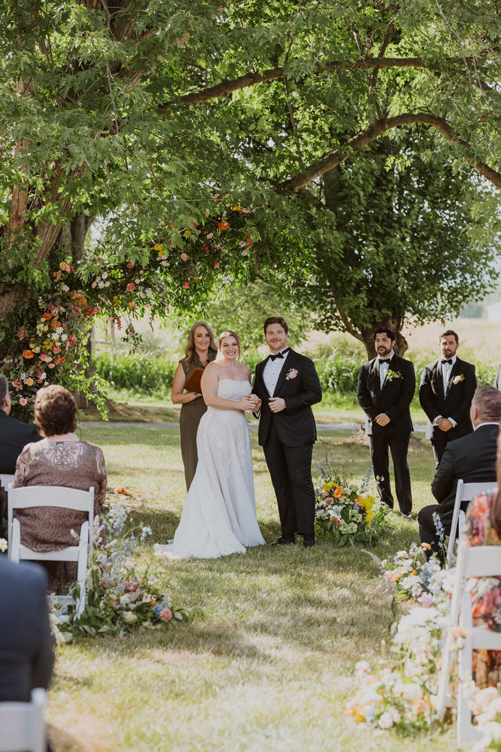 couple exchanges vows under tree  at The Manor at Airmont wedding