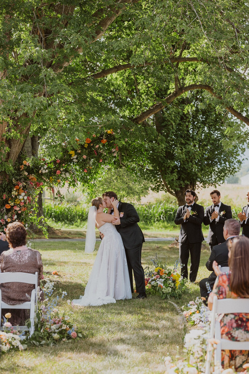 couple kisses under tree at The Manor at Airmont wedding ceremony