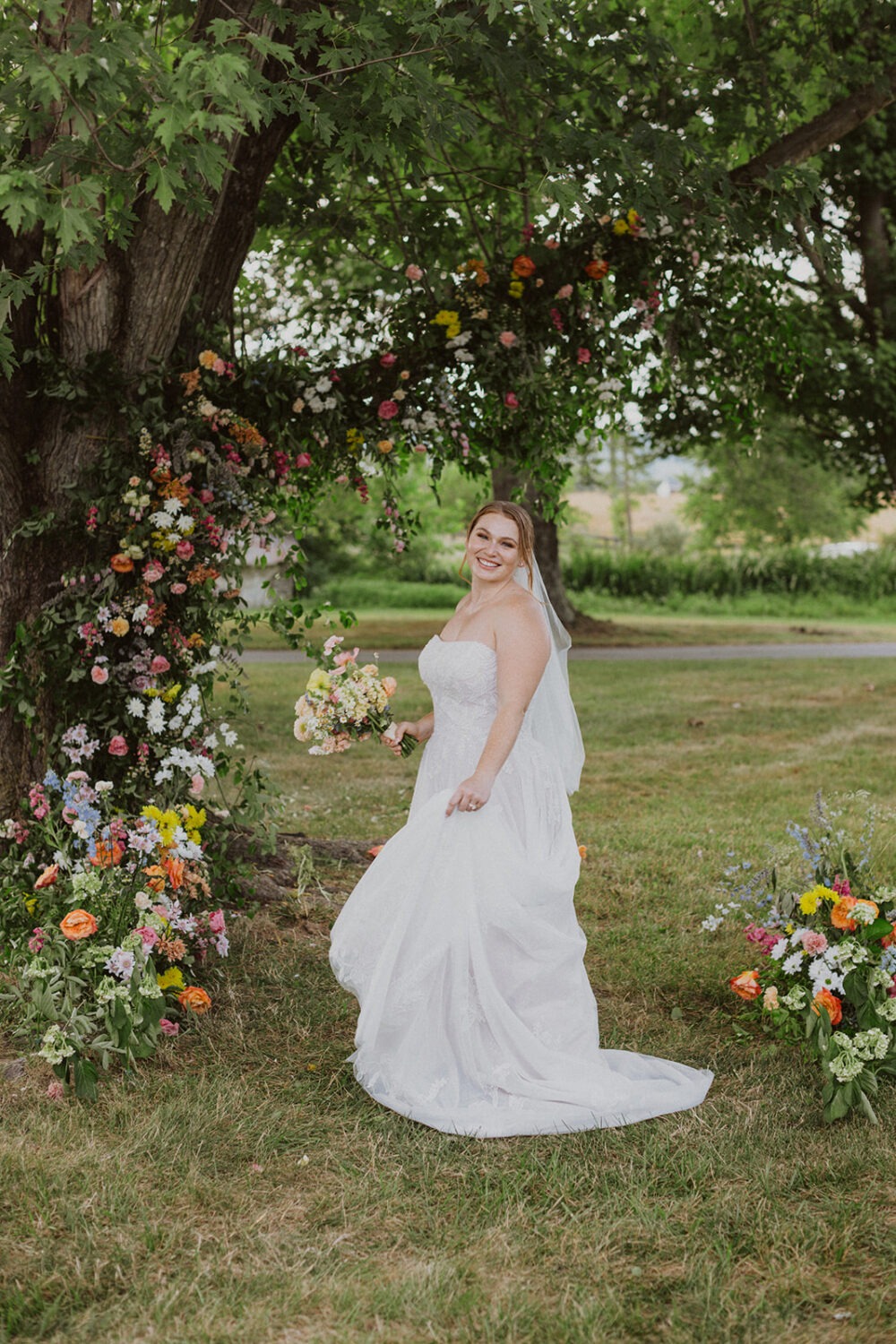 bride holds wedding bouquet under wedding florals