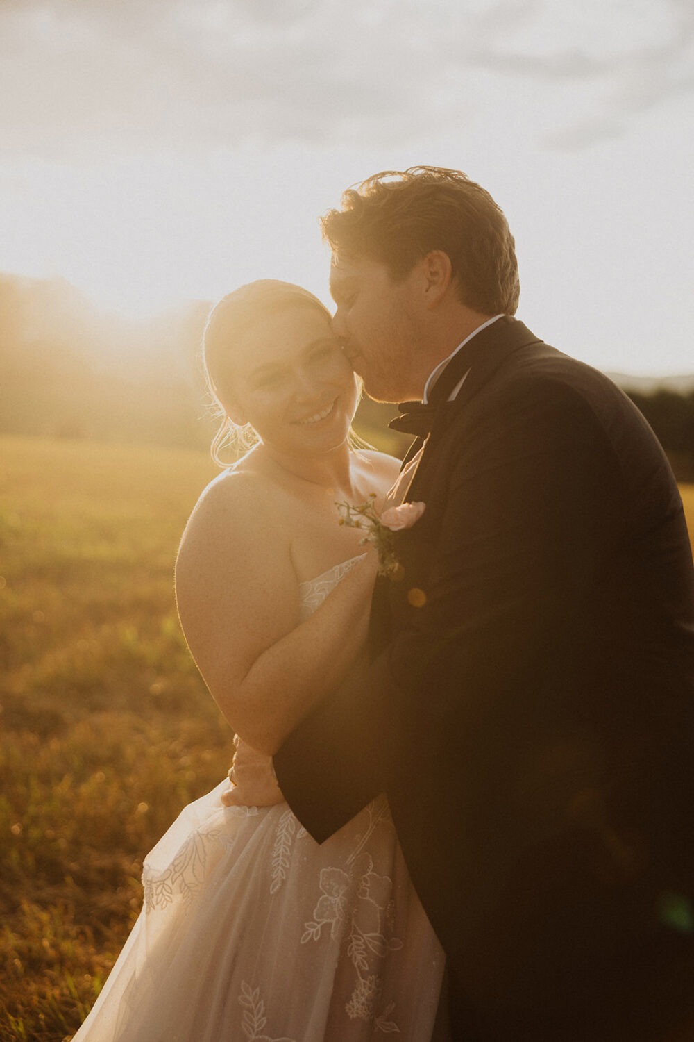 couple kisses during outdoor wedding venue sunset