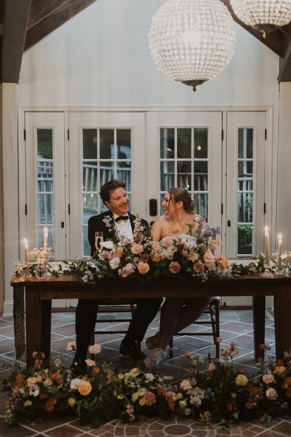 couple sits at table using wedding florist ideas