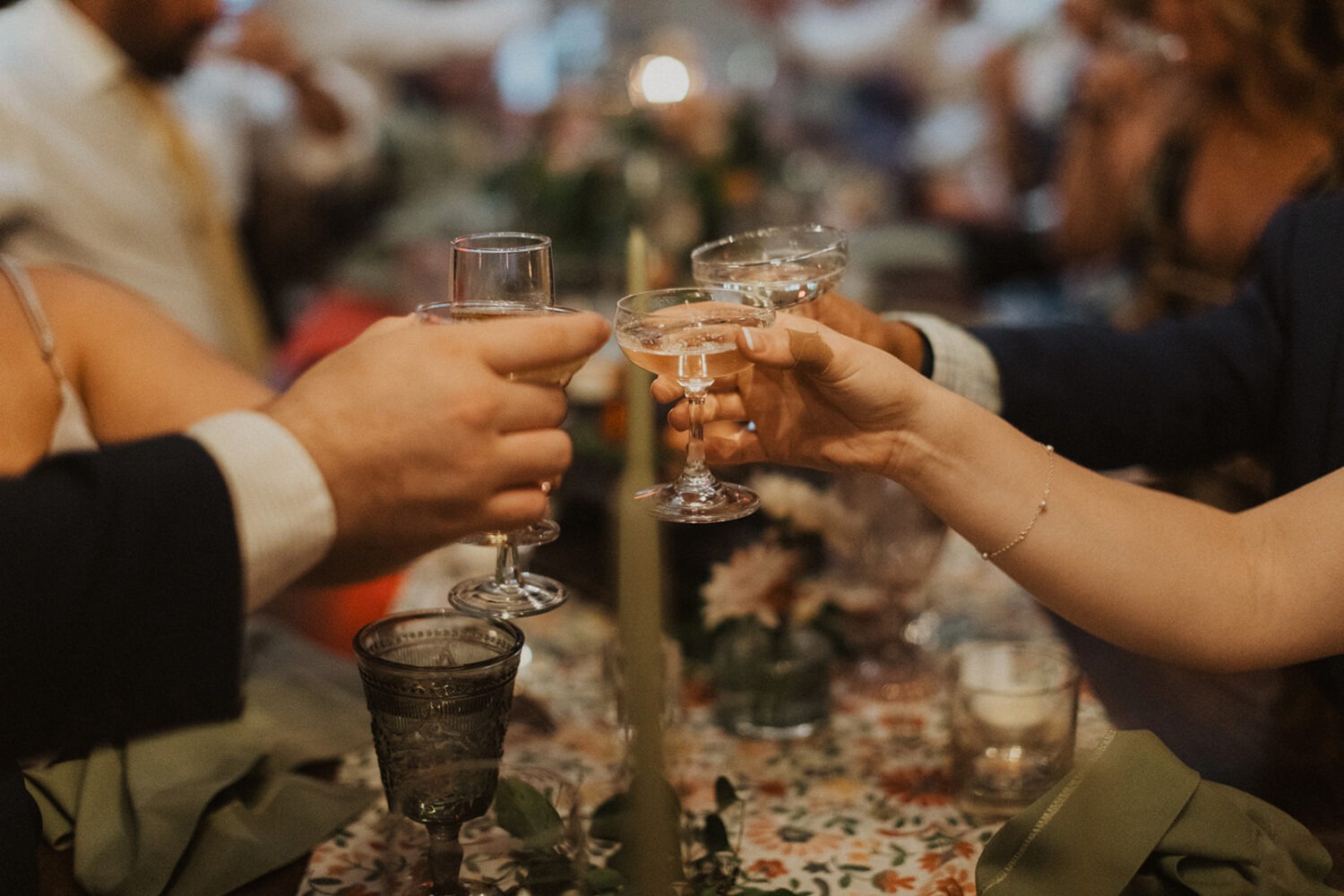 wedding guests clink coups together during toast