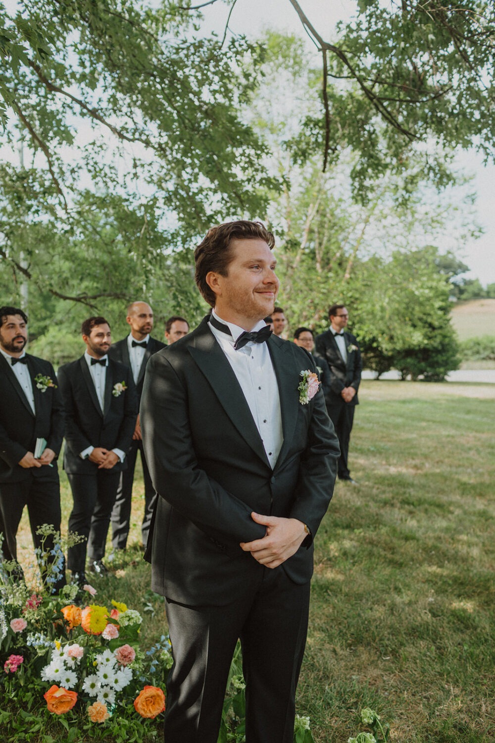 groom watches bride walk down aisle during ceremony