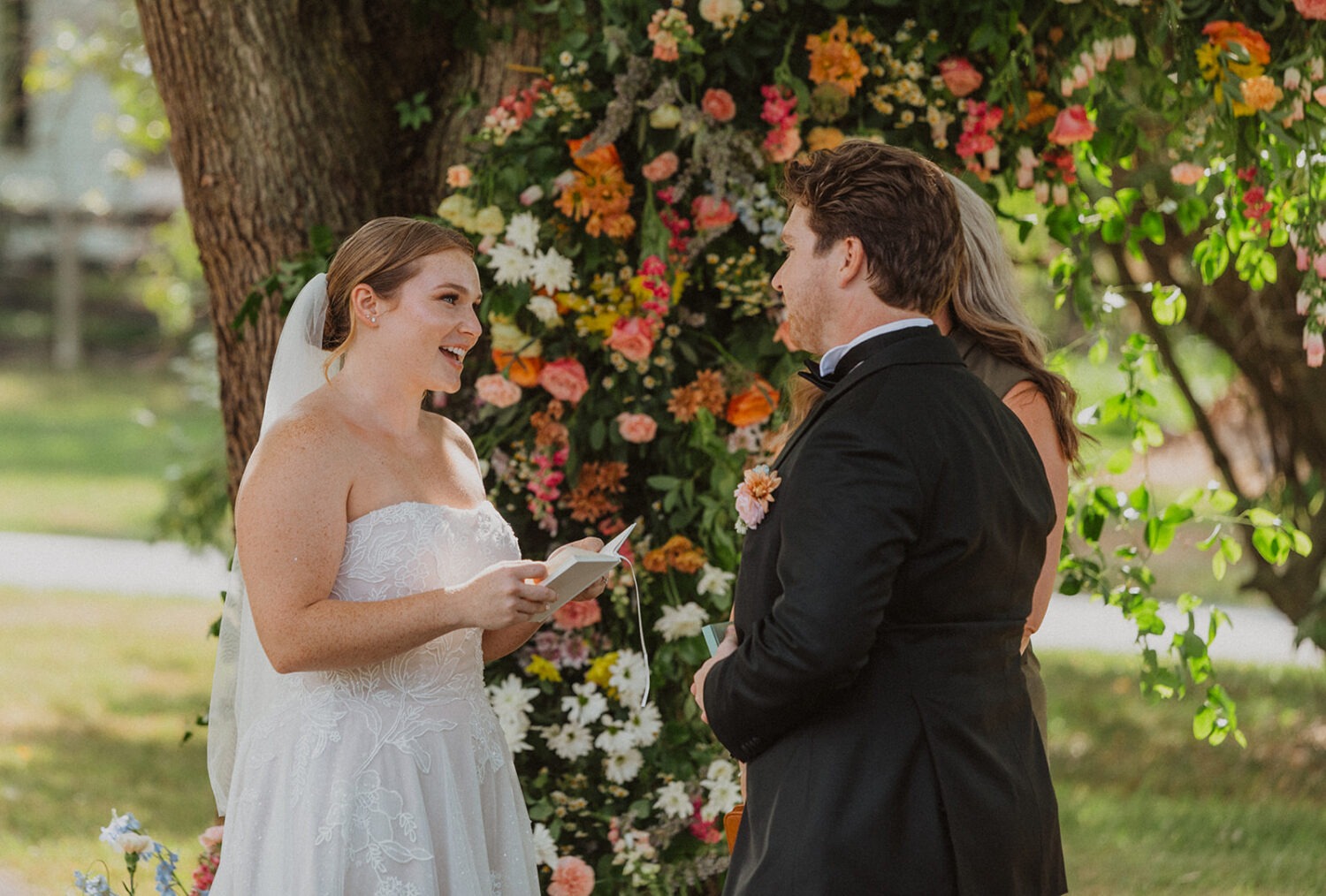 couple exchanges vows in front of wedding florist ideas for florals