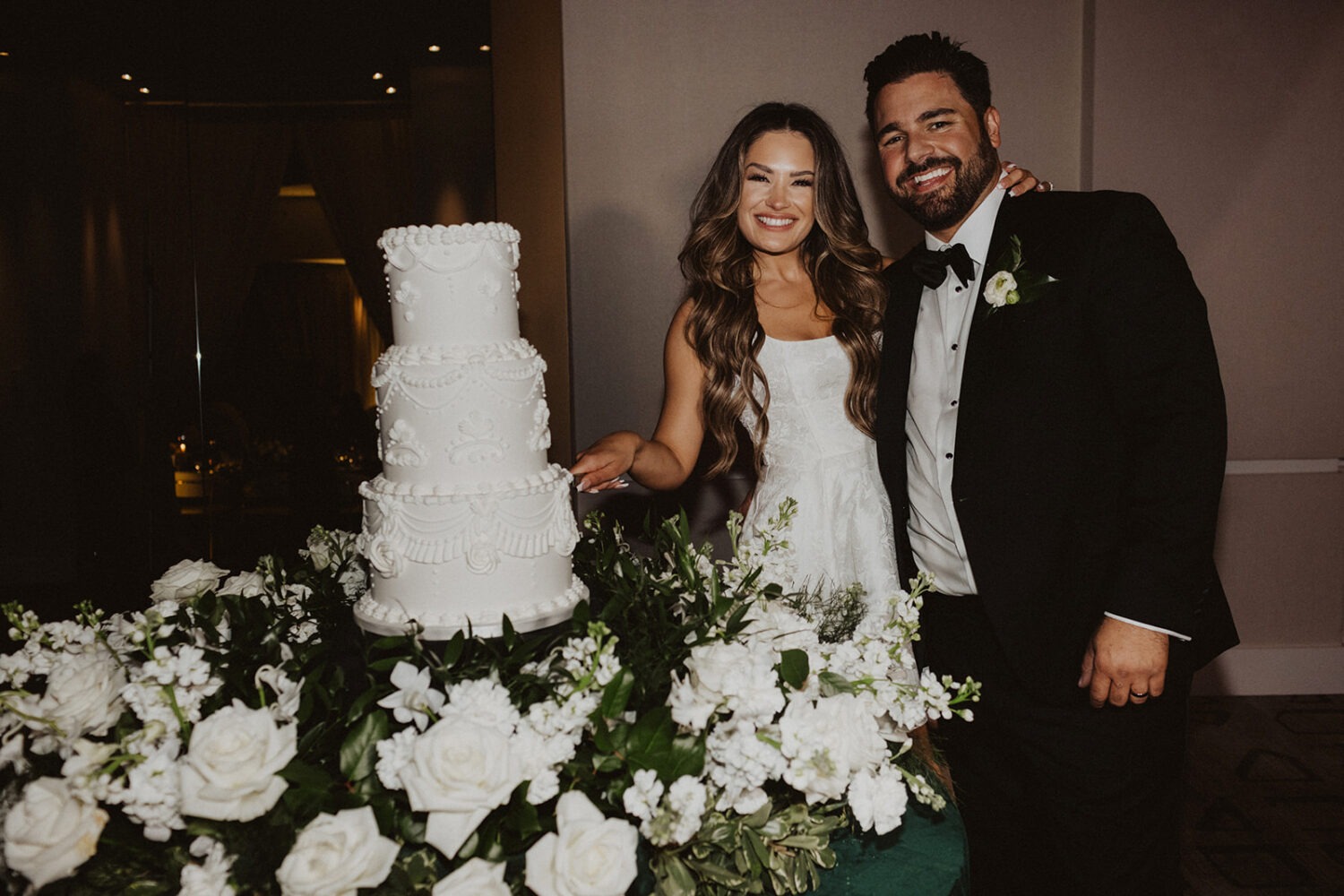 couple cuts cake during wedding reception