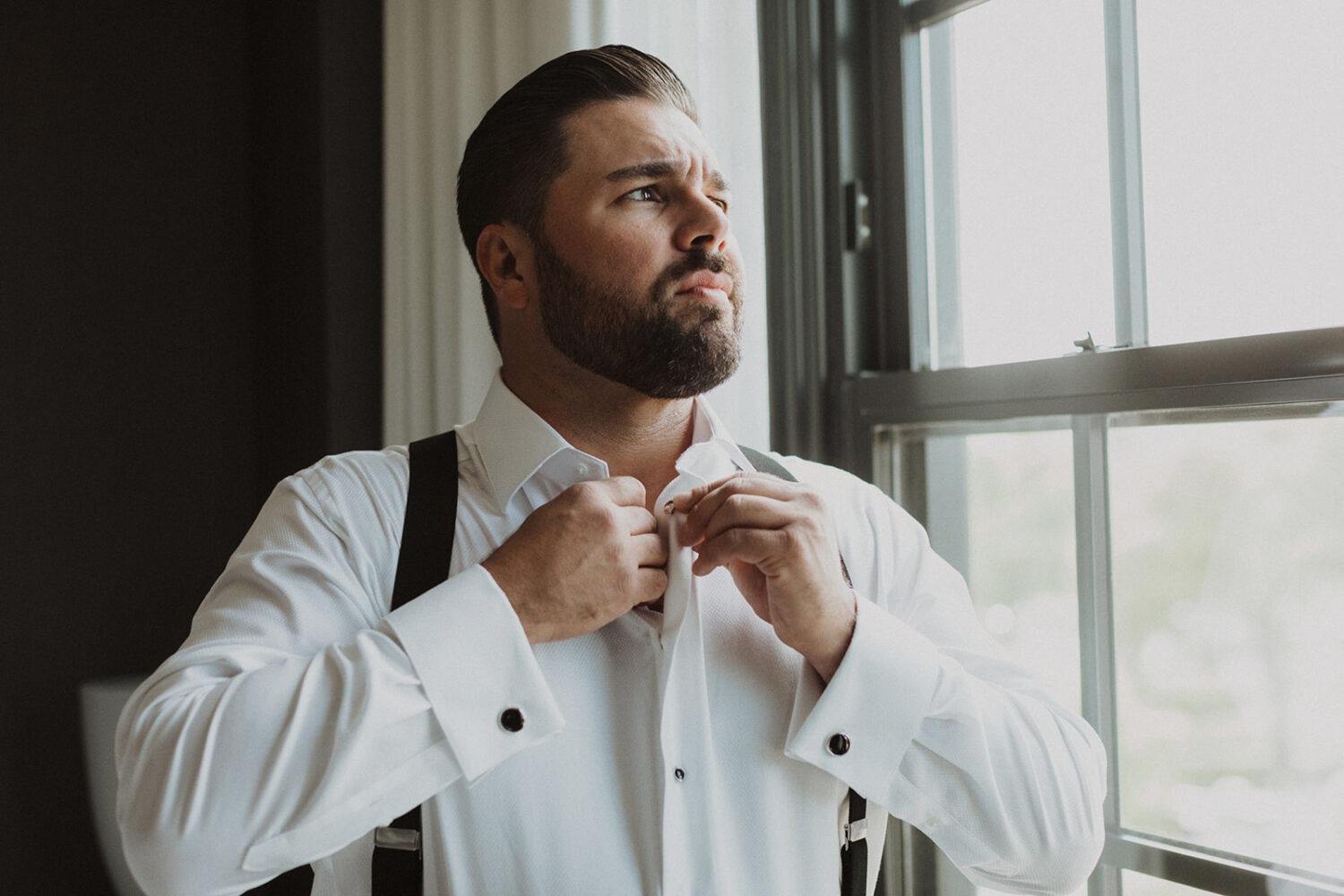 groom buttons shirt during wedding getting ready