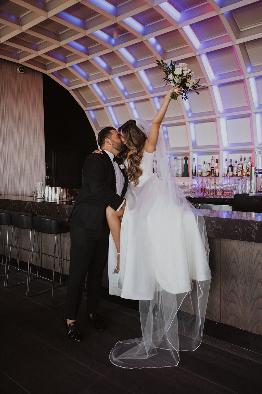 couple kisses on bar for wedding photo shoot ideas