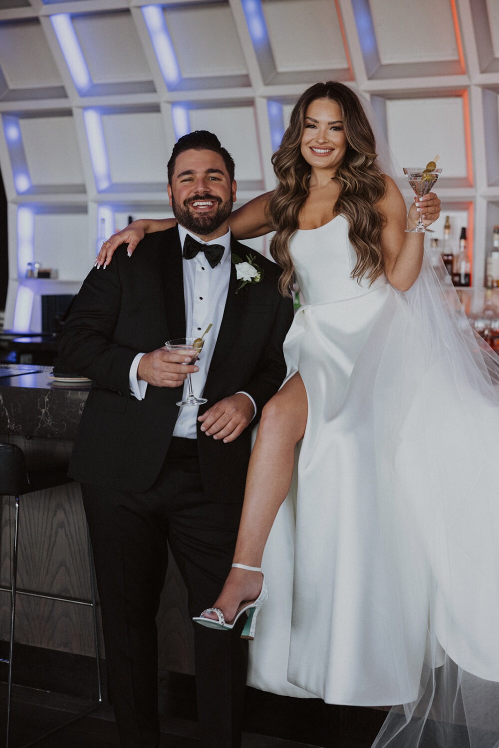 couple sips cocktails on bar for wedding photo shoot ideas