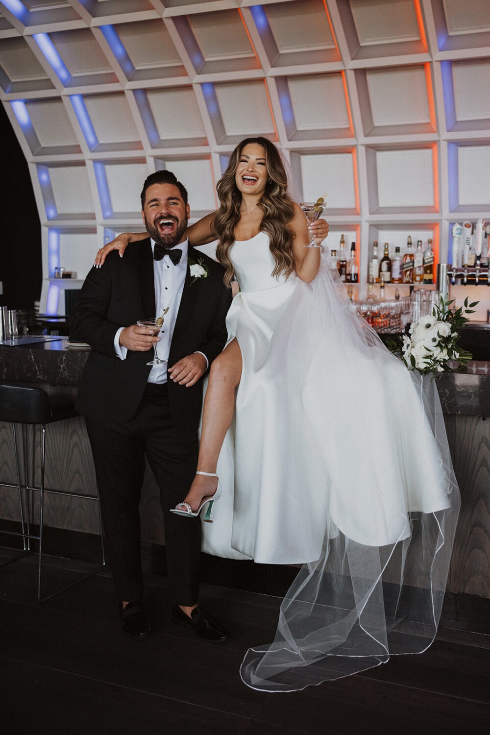 couple sips cocktails on bar for wedding photo shoot ideas