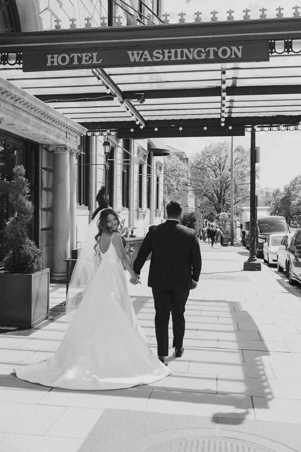 couple walks holding hands at Hotel Washington for wedding photo shoot ideas