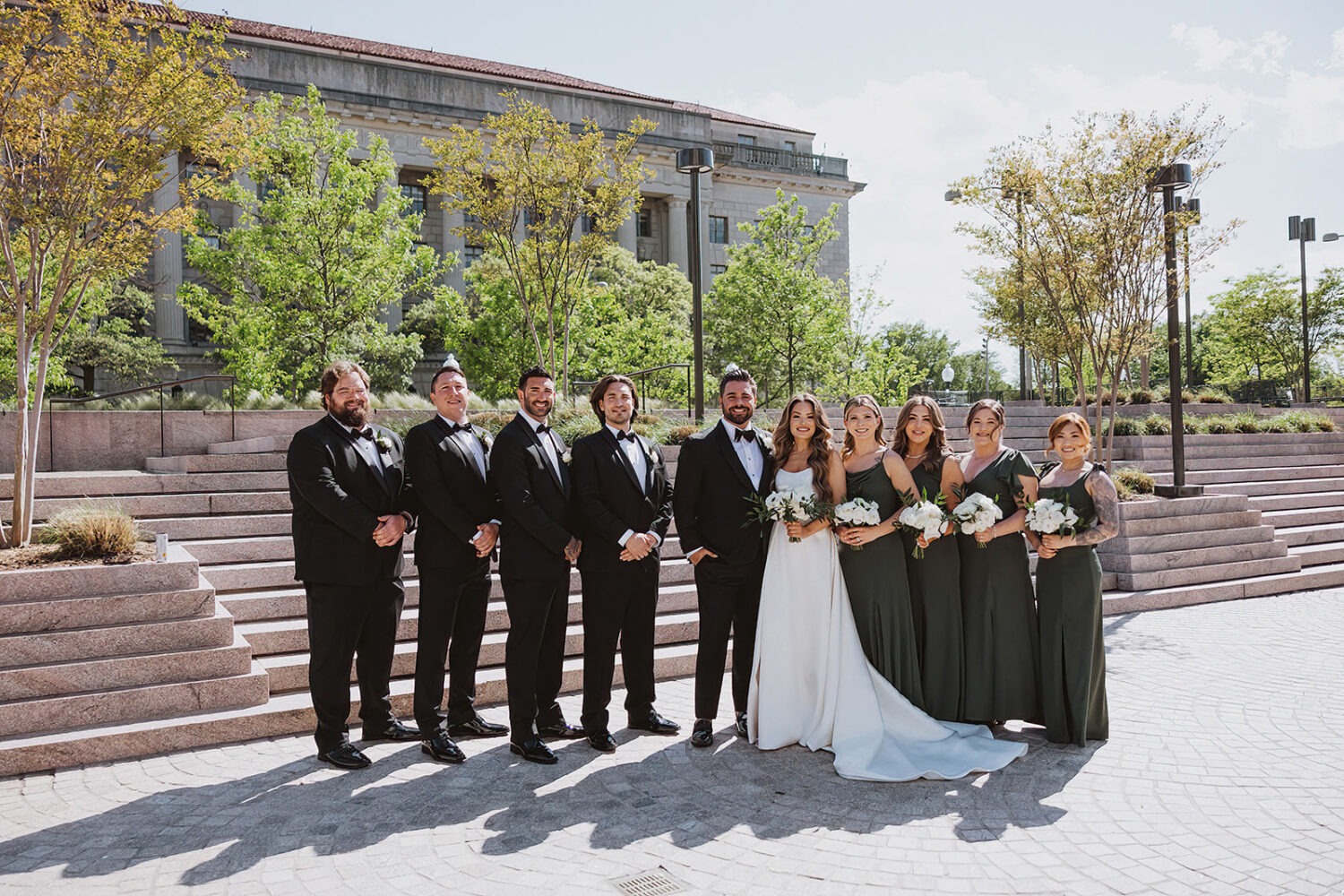 couple poses with wedding party at outdoor DC wedding 