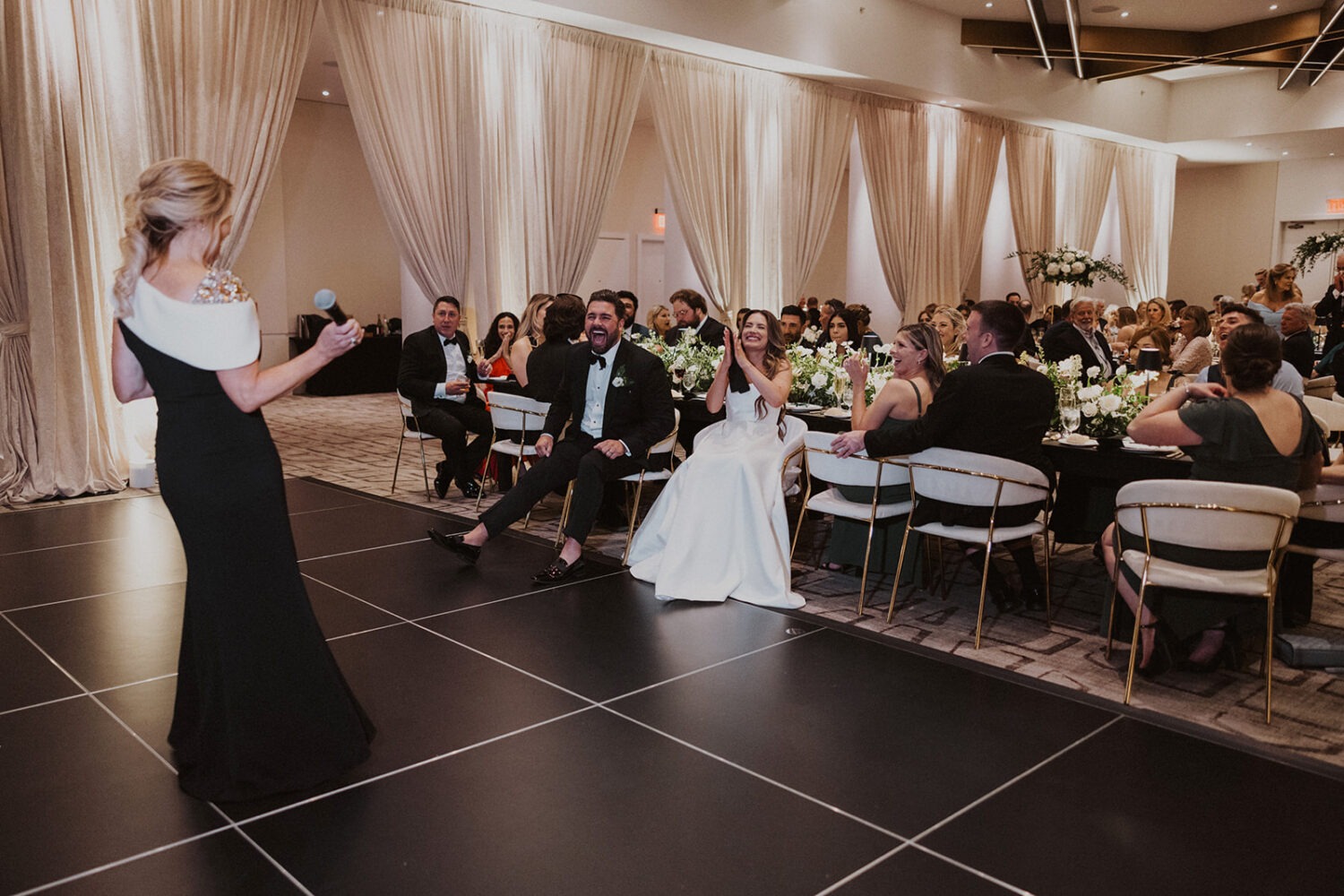 couple laughs during wedding reception speeches 