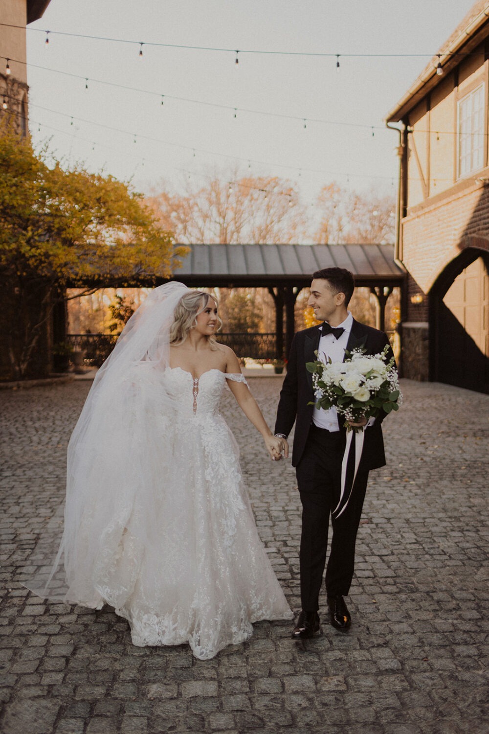 couple walks holding hands at historic Virginia wedding estate