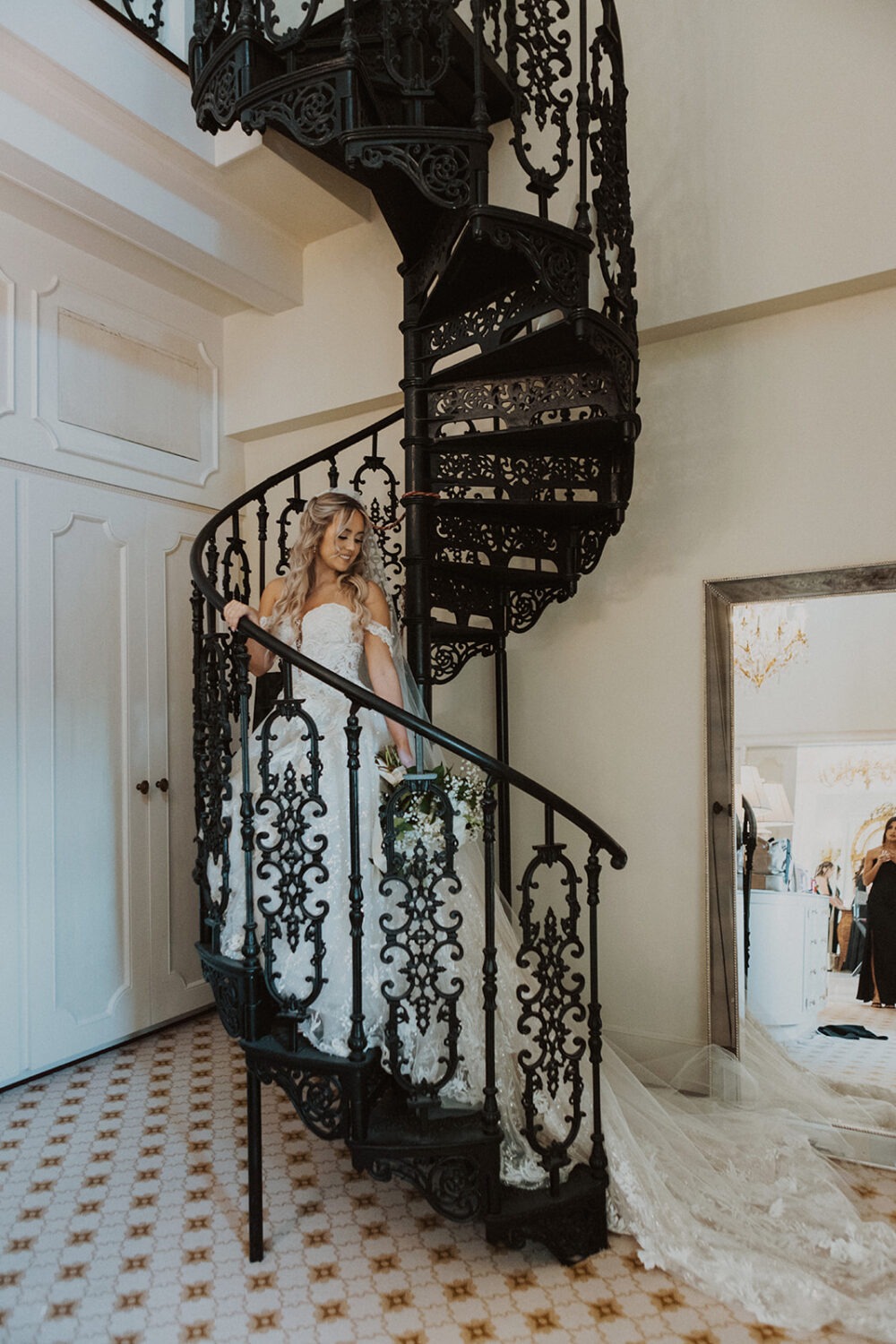 bride stands on spiral staircase at Dover Hall Virginia wedding venue