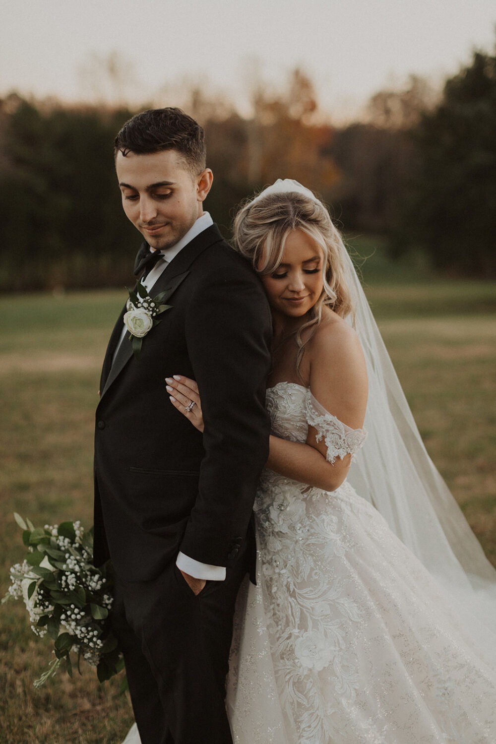 couple embraces in field at Dover Hall Virginia wedding venue