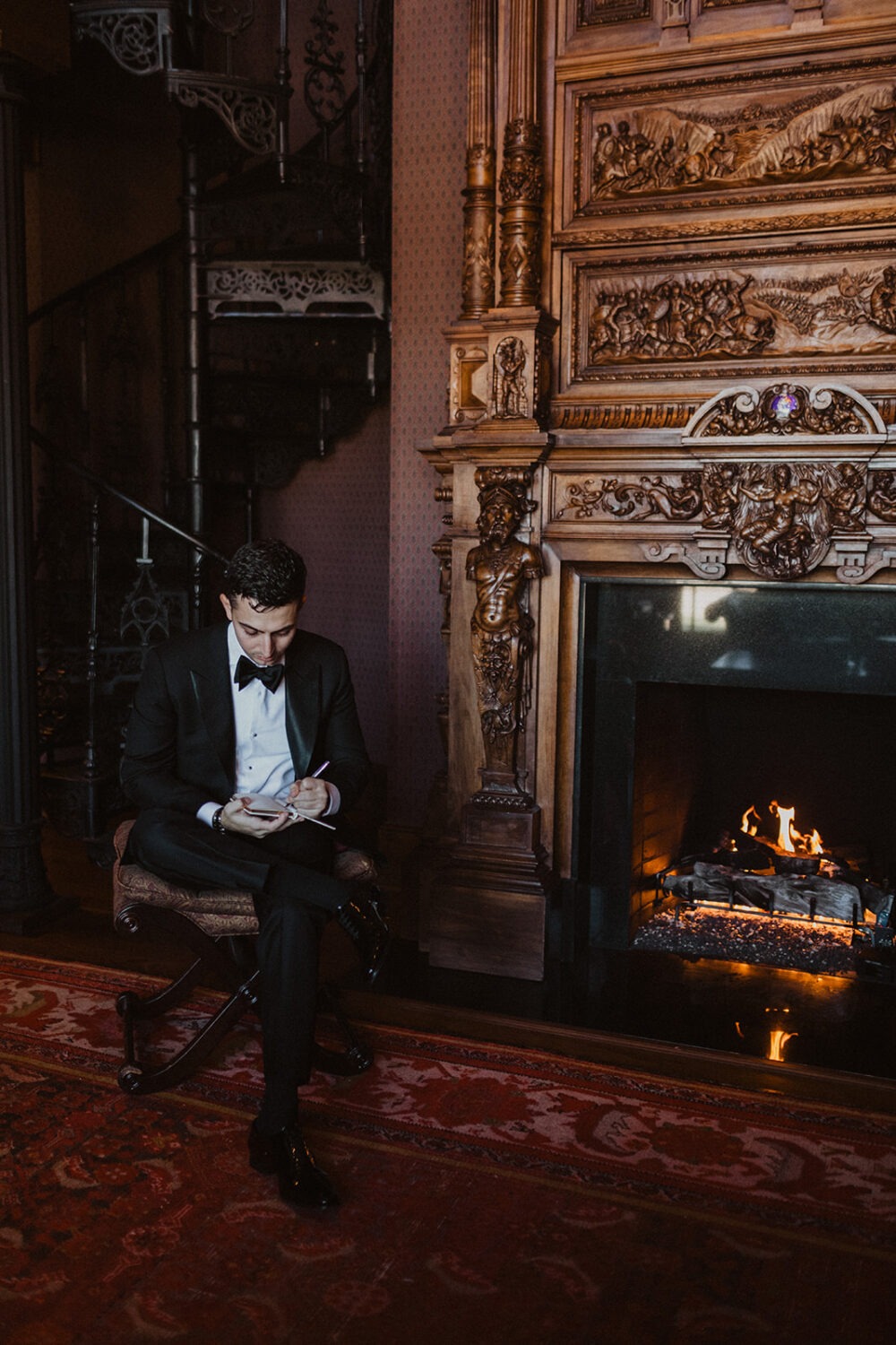 groom writes vows next to fireplace at Dover Hall Virginia wedding venue