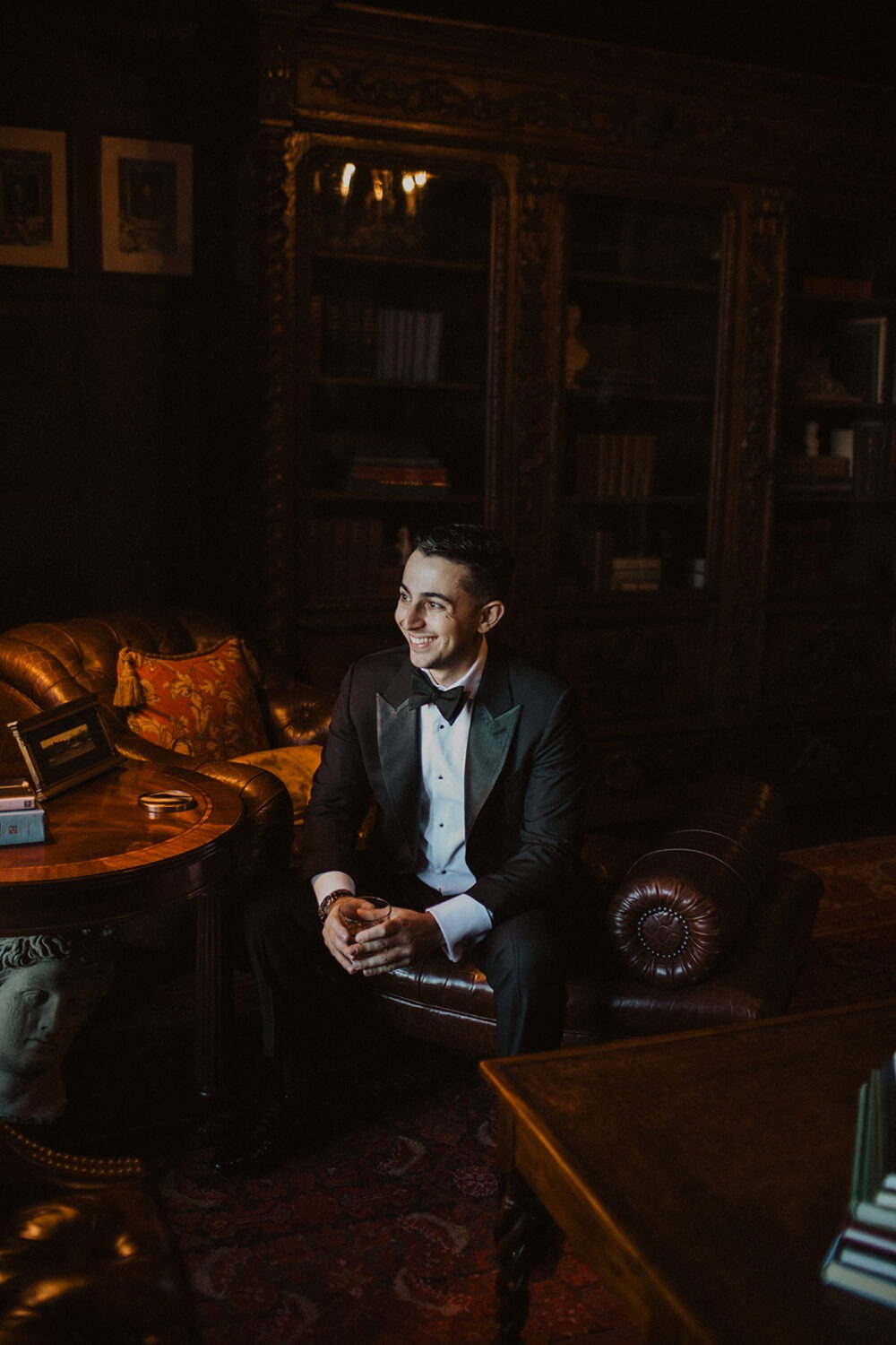 groom sits in getting ready suite at Dover Hall Virginia wedding venue