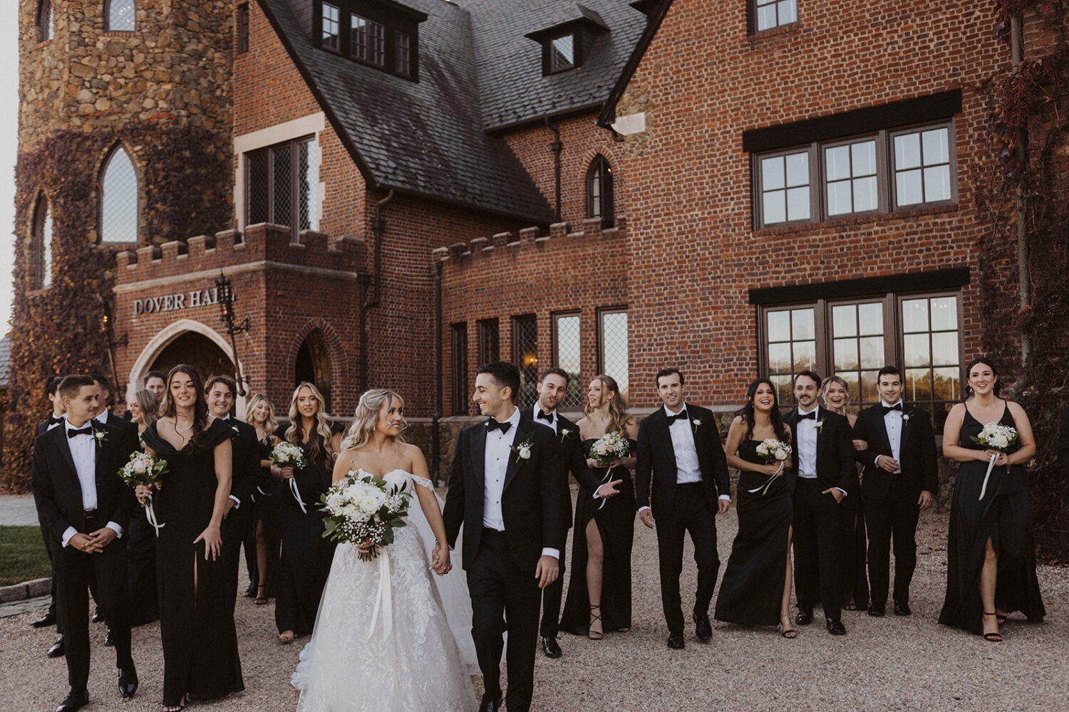 couple walks with wedding party at Dover Hall Virginia wedding venue