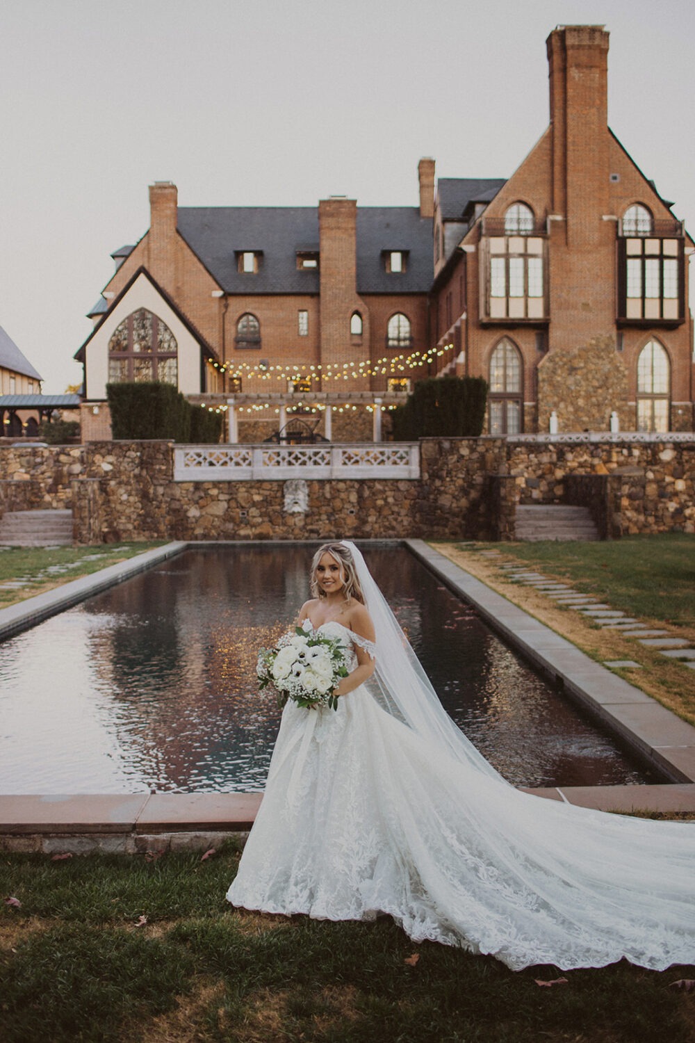 couple holds wedding bouquet beside reflection pool at Dover Hall Virginia wedding venue