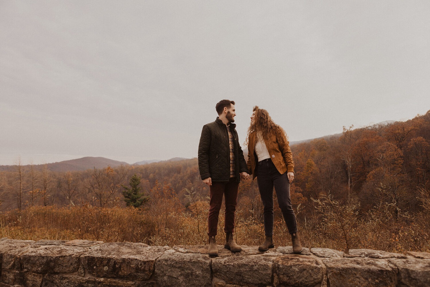 couple stands on overlook at Shenandoah fall engagement photos