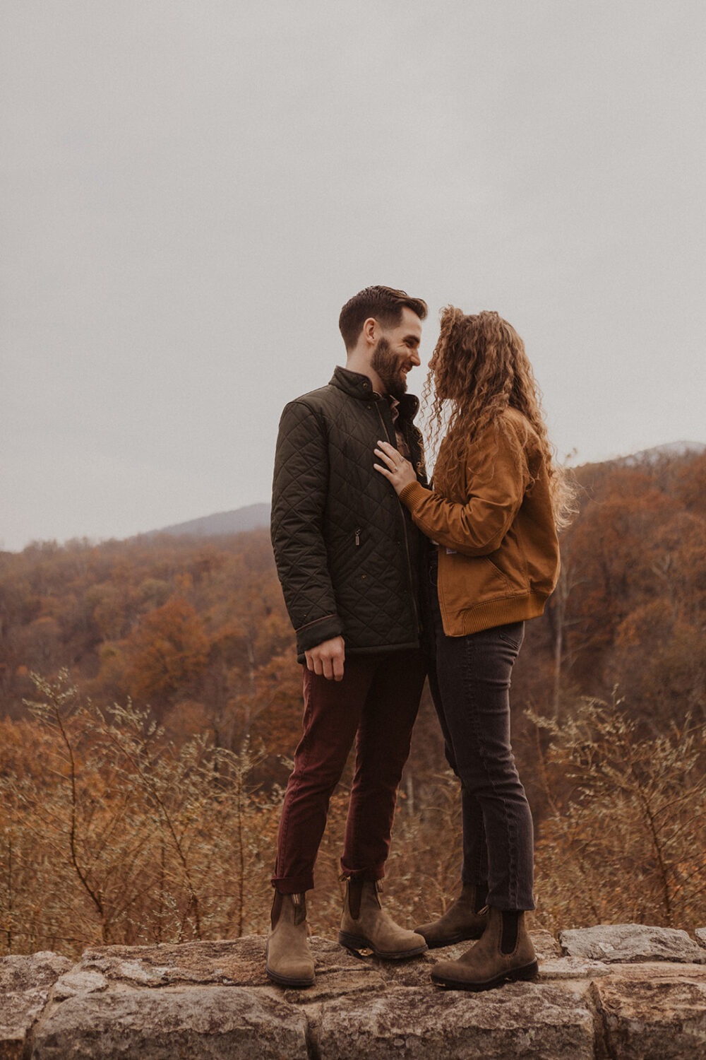 couple stands on overlook at Shenandoah fall engagement photos