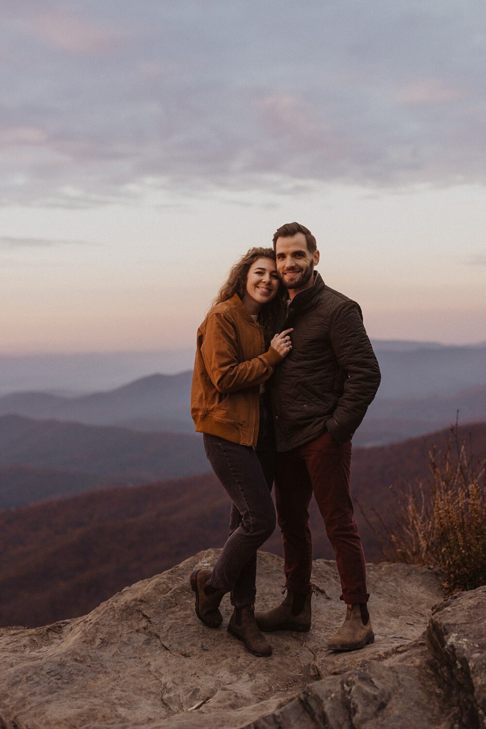 couple embraces on overlook for Shenandoah fall engagement photos