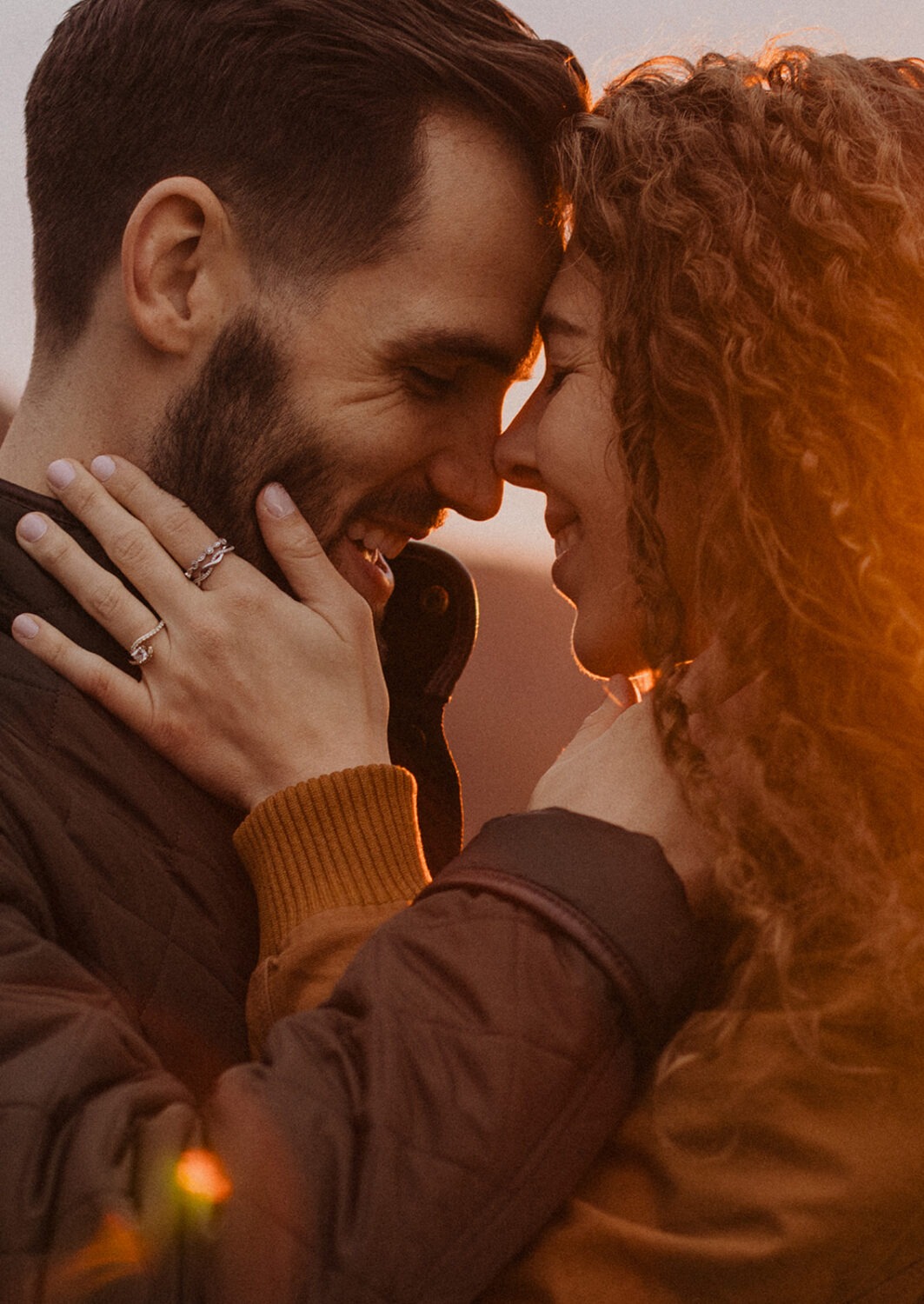 couple embraces during sunset engagement photos