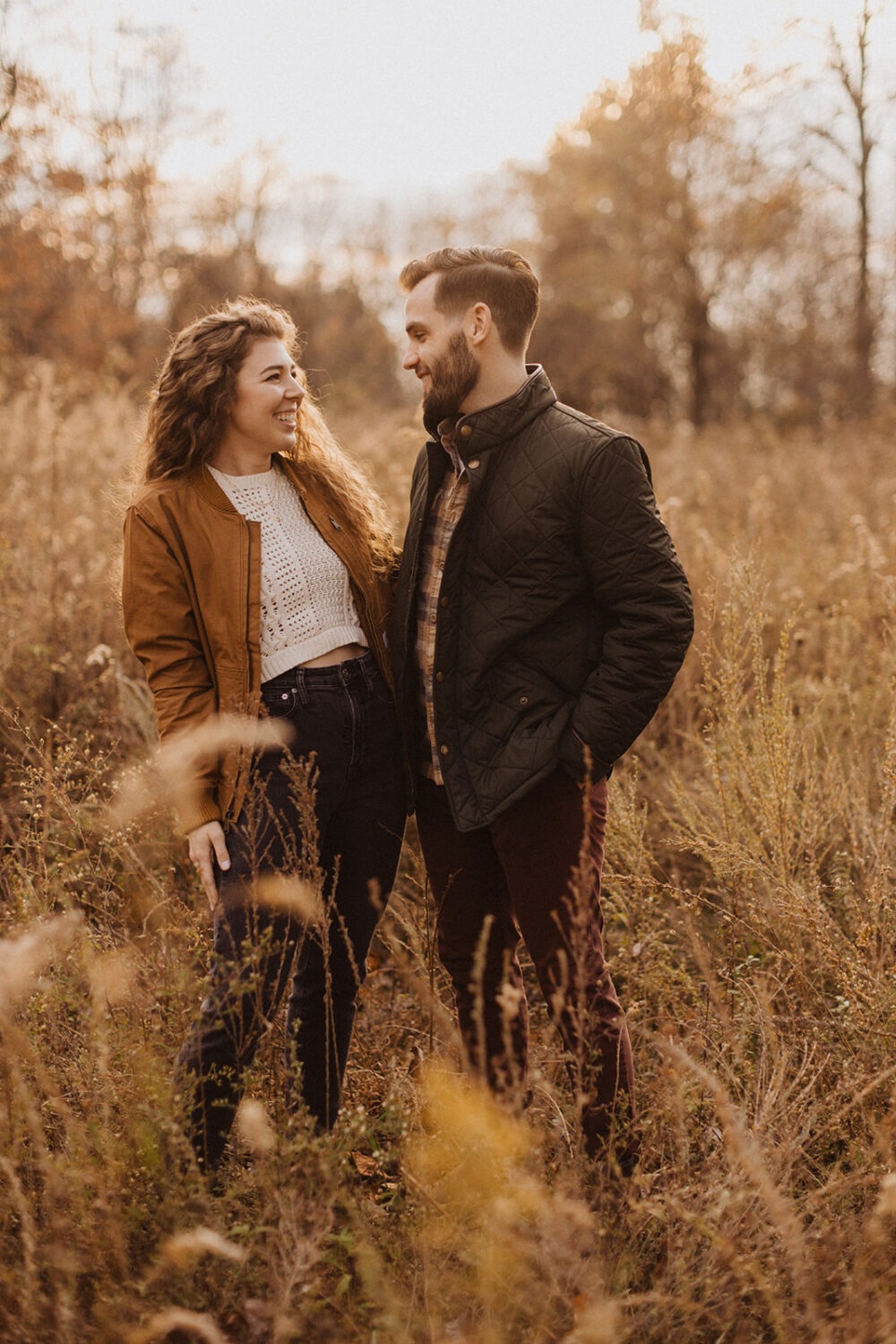 couple stands in field during Shenandoah sunset engagement session