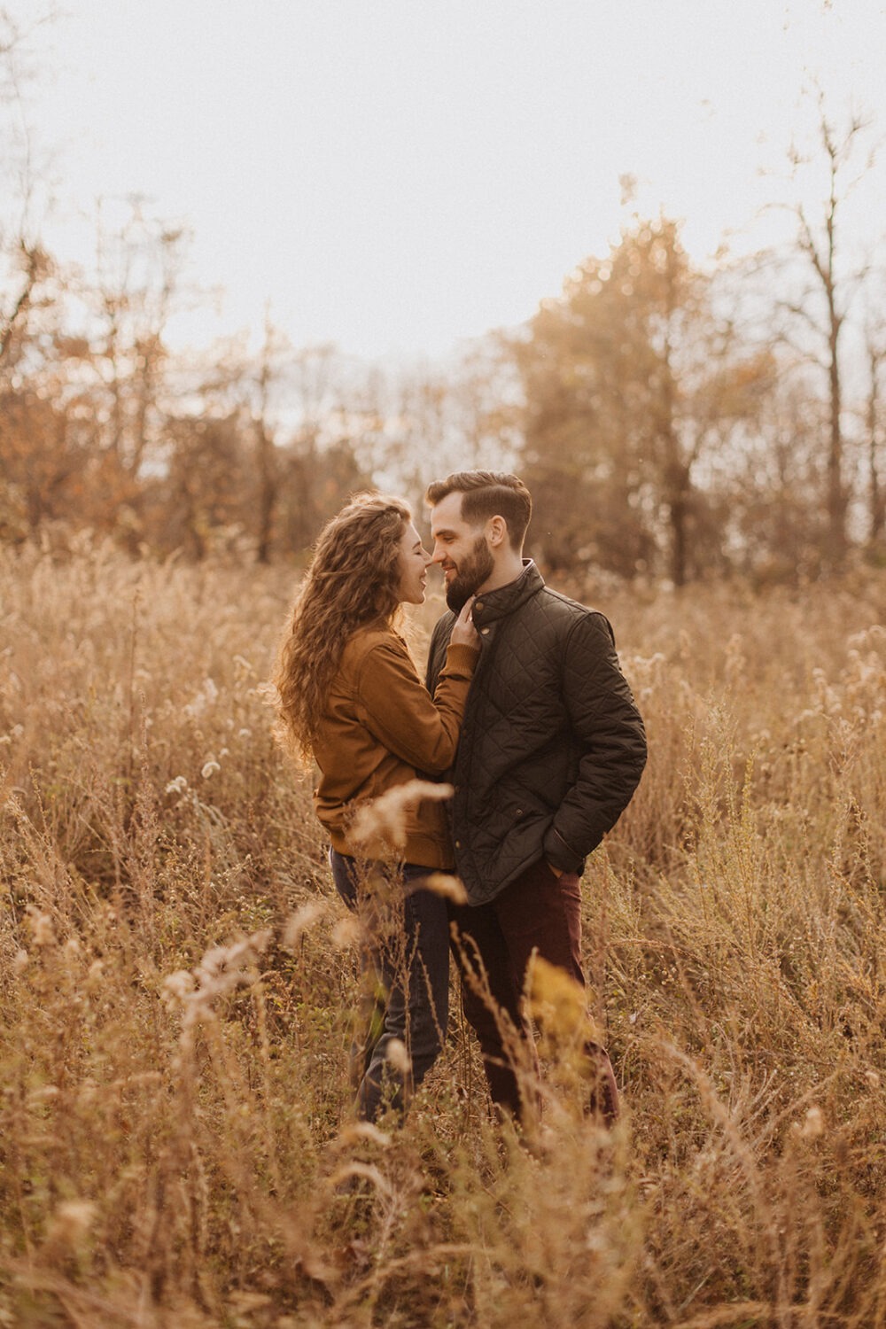 couple embraces in field for Shenandoah fall engagement photos