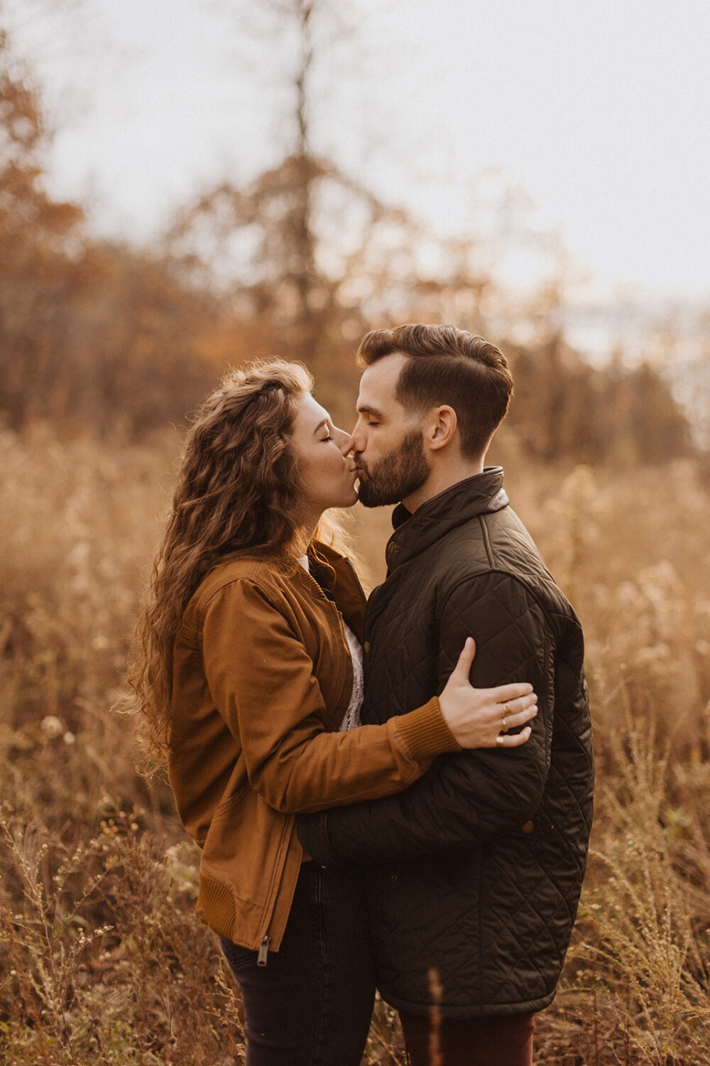 couple kisses in field for Shenandoah fall engagement photos