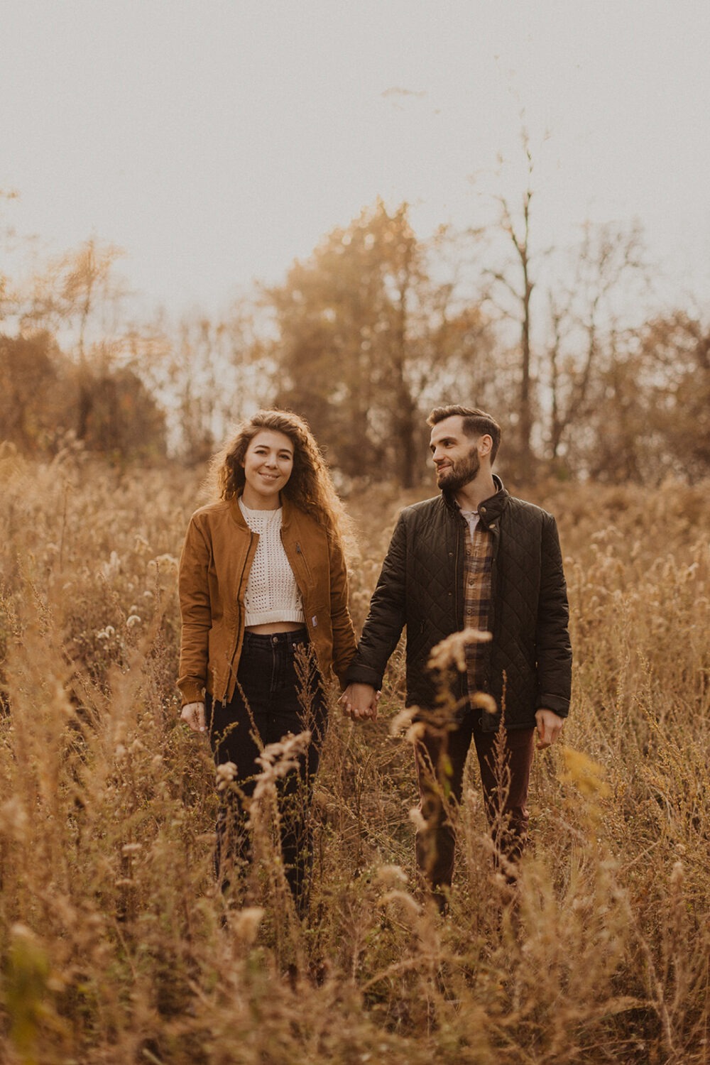 couple stands in field during Shenandoah sunset engagement session