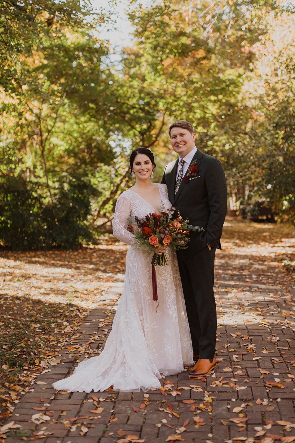 couple stands under fall trees at DC wedding