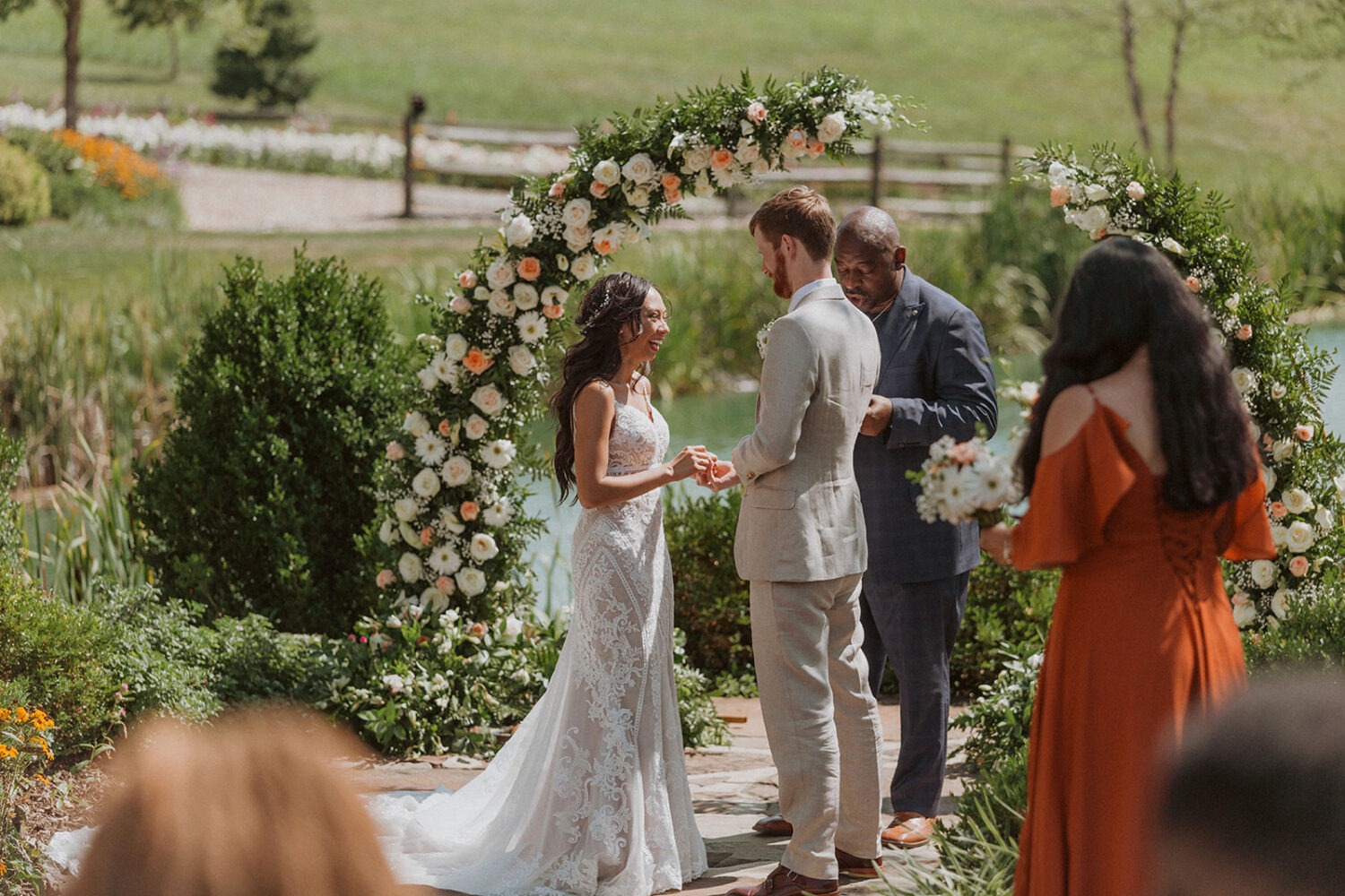 couple exchanges vows under wedding floral arch